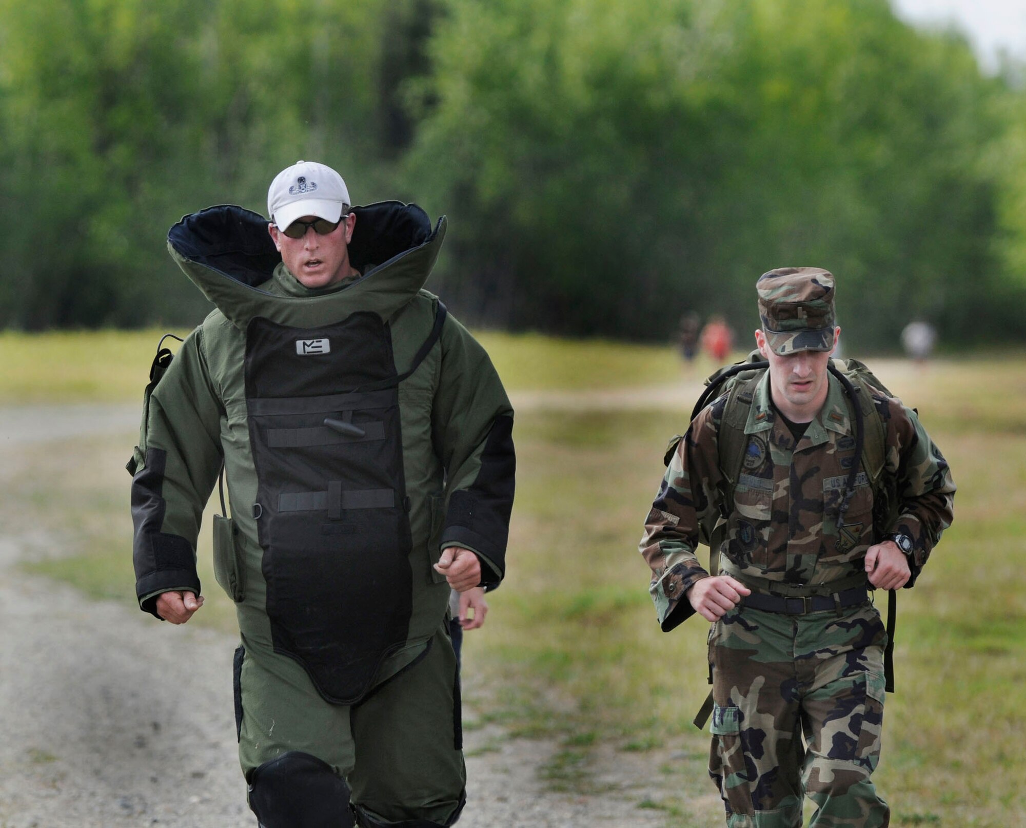 Master Sgt. Heath Tempel runs along side a medic in the 75-pound bomb suit during a 5K run May 30, 2009, North Pole, Alaska. Running the 5K in the bomb suit signifies suffering of wounded teammates while raising money for the Wounded Explosive Ordnance Disposal Warrior Foundation. Sergeant Tempel is an EOD technician with the 354th Civil Engineering Squadron Explosive Ordnance Flight. (U.S. Air Force photo/Airman 1st Class Laura Max)