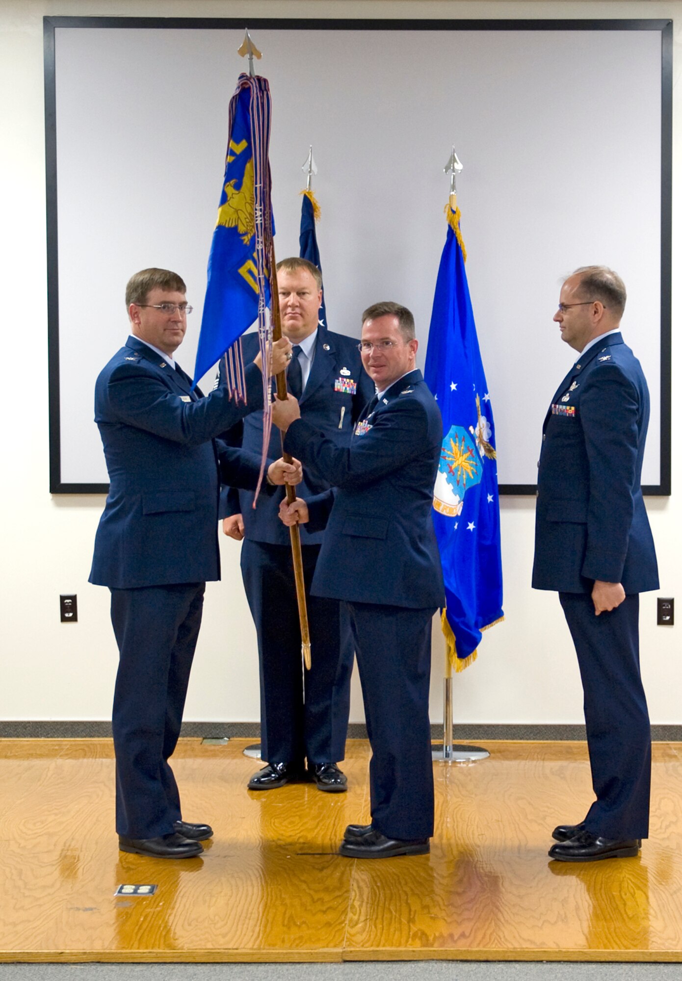 Col. Michael Fabian (left), Air Force Research Laboratory Propulsion Directorate deputy director, passes the AFRL Propulsion Directorate Edwards site guidon to Col. David Blanks (center) as Col. Alexander Giczy (right), former Edwards site commander, and Senior Master Sgt. Jeff Buetemeister (rear), AFRL Propulsion Directorate Edwards site superintendent, look on during the AFRL Edwards site change of command ceremony June 1. (Courtesy photo)