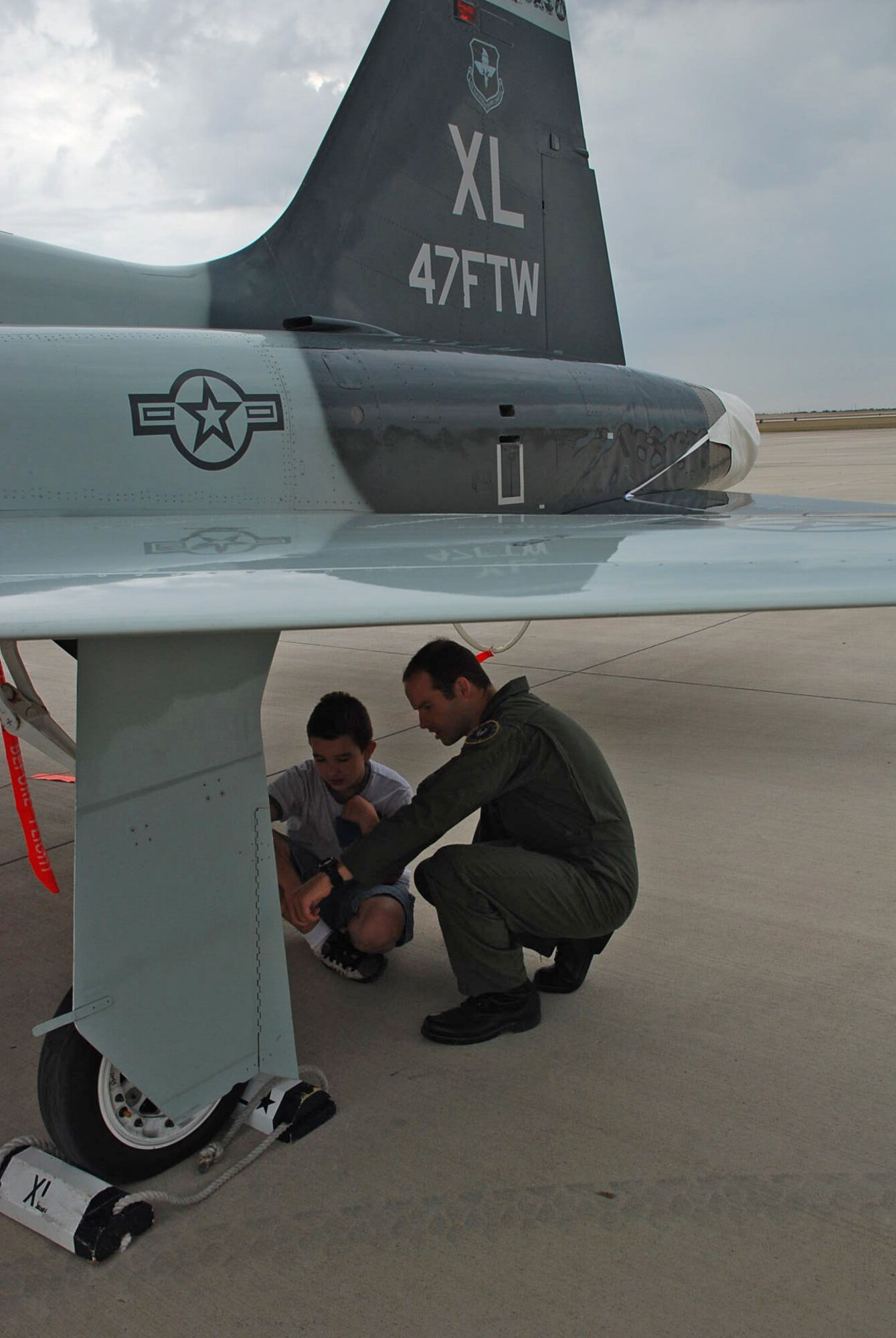 LAUGHLIN AIR FORCE BASE, Texas--Capt. Jason Tingstrom, 47th Operations Support Squadron and Laughlin Education Enrichment Program mentor, explains parts of the T-38 Talon to a Ruben Chavira Elementary School student here May 29. The program, LEEP, was developed as way to help students excel in a non-threatening, motivating environment by pairing each student with a Laughlin Airman to be their mentor.  Twenty-five students participated in a base tour that was organized by the Laughlin mentors as a capstone event to end the school year and recognize the students' achievements.  (U.S. Air Force photo by Airman 1st Class Sara Csurilla)