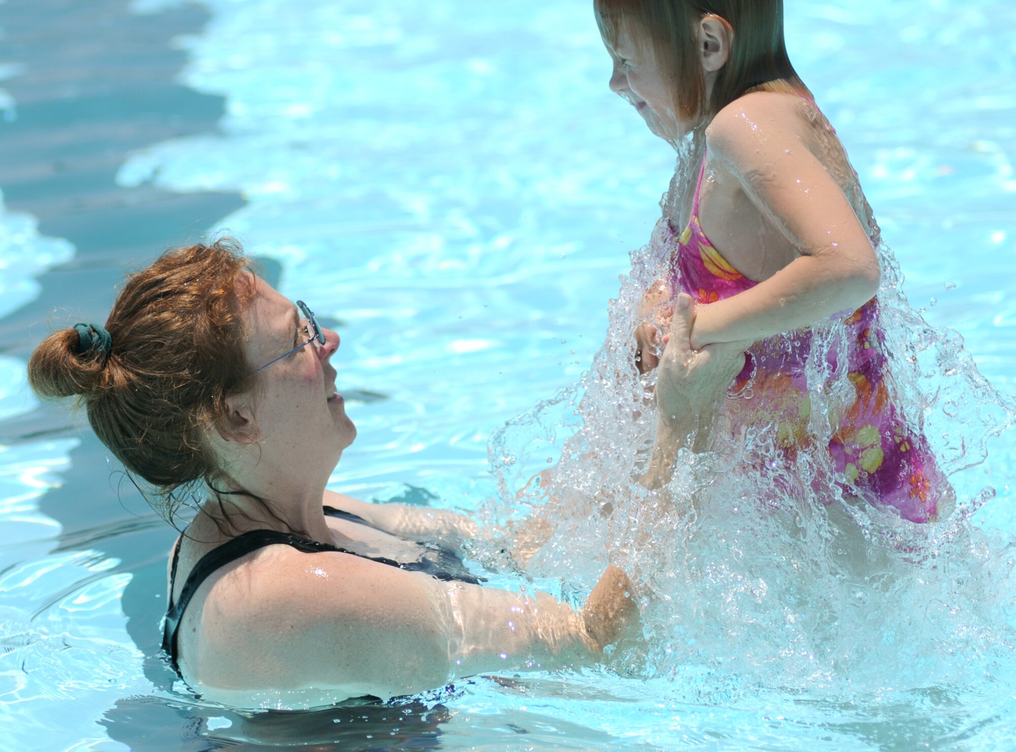 Ann Schuett, spouse of Tech. Sgt. Carl Schuett, 81st Training Support Squadron, and their 7-year-old daughter, Ashley, enjoy a swim Monday at the Triangle Pool.  (U.S. Air Force photo by Kemberly Groue)