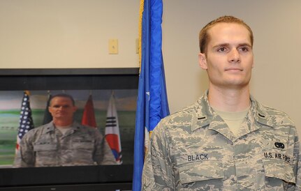 Then-1st Lt. Travis Black, 87th Logistics Readiness Squadron Materiel Management Flight commander,  prepares to take the oath of office administered by his father, Lt. Col. Steven Black, chief of nutritional medicine at Bagram Air Base, Afghanistan, via video teleconference May 29. Captain Black and his family had not seen the lieutenant colonel since he deployed four and a half months ago. (U.S. Air Force photo/Staff Sgt. Danielle Johnson)