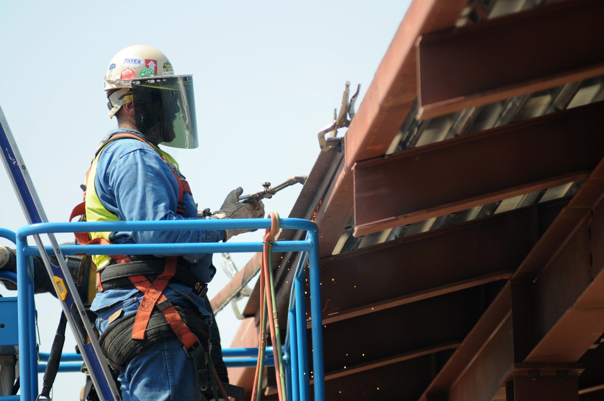 Welder Billy Sangster from Cheyenne Steel works on the perimeter angle of the post office’s roof Monday.  Roof decking is finished in preparation for installation of the roofing system.  Structural steel erection is completed and rough-ins of the interior mechanical, plumbing and electrical systems have been initiated.  (U.S. Air Force photo by Kemberly Groue)