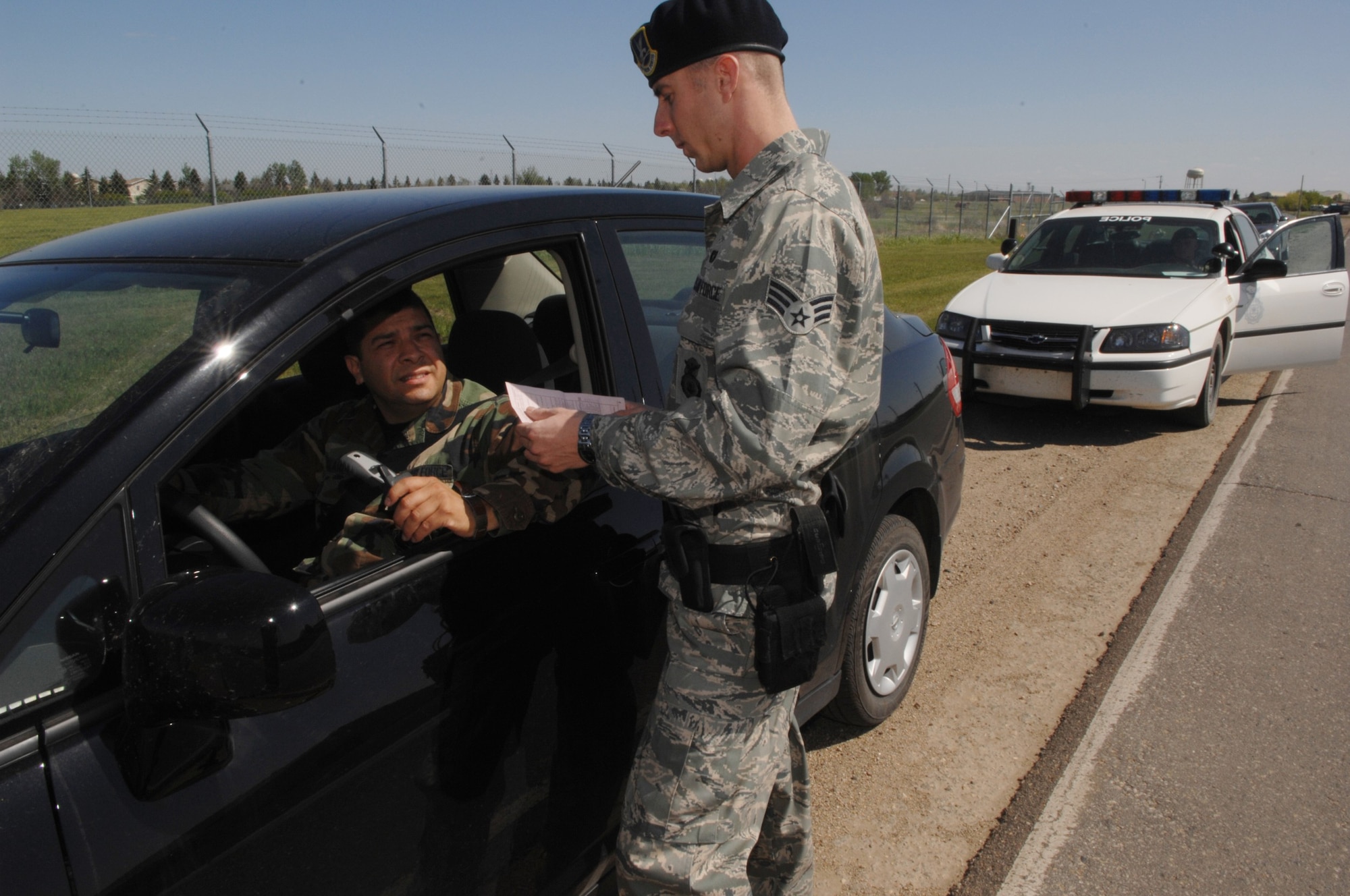 MINOT AIR FORCE BASE, N.D. -- Senior Airmen Brian Sollis, 5th Security forces Squadron pulls over a motorist using a phone without a hands-free device while driving on base.  Using a cell phone without a hands-free device while operating any vehicle on Minot AFB will result in a ticket and three points assessed against the offender’s driving record. (U.S. Air Force Photo by Staff Sgt. Stacy Moless)