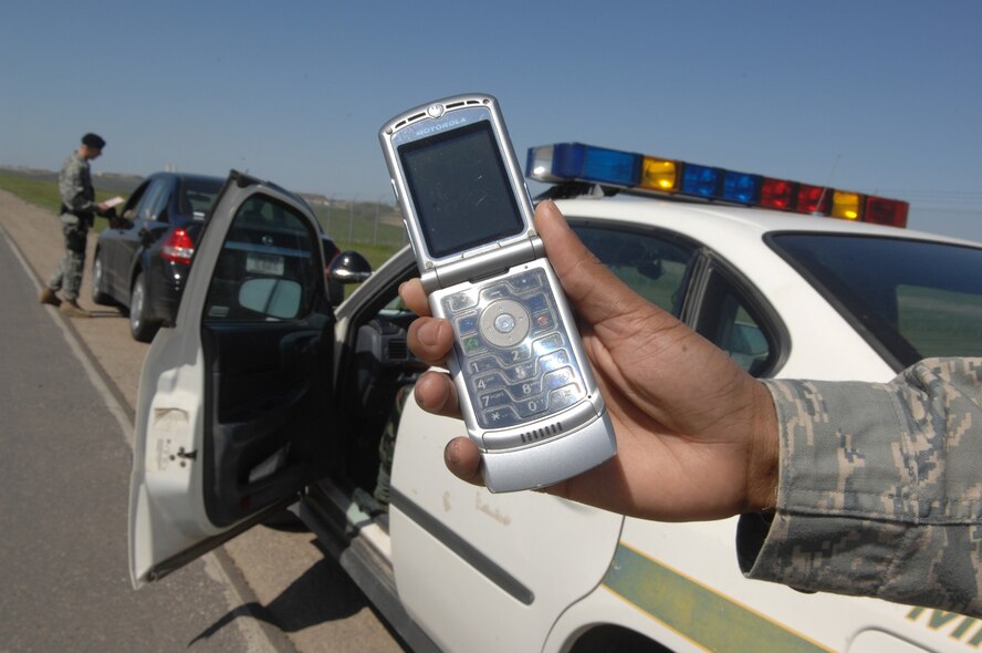 MINOT AIR FORCE BASE, N.D. -- Senior Airmen Brian Sollis, 5th Security forces Squadron pulls over a motorist using a phone without a hands-free device while driving on base.  Using a cell phone without a hands-free device while operating any vehicle on Minot AFB will result in a ticket and three points assessed against the offender’s driving record. (U.S. Air Force Photo by Staff Sgt. Stacy Moless)