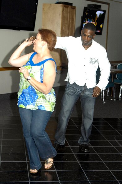 Tech. Sgt. Nigel Skeete, 2d Maintenance Operation Squadron non-commissioned officer in charge of plans, scheduling and documentation and attendee, Ivonne Aluarez, are the first couple to hit the dance floor during Latin Night May 29 at the Stripes Club. This was the second Latin night held at the club and organizers plan to have many more.(U.S. photo by Airman 1st Class Allison M. Boehm)(RELEASED)