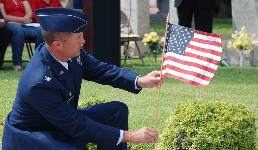 LAUGHLIN AIR FORCE BASE, Texas – Col. Andrew Cernicky, 47th Mission Support Group commander, places an American flag on a marker during the Memorial Day ceremony held May 30 at San Felipe Cemetery in South Del Rio.  Colonel Cernicky was the speaker and Laughlin Honor Guard members worked with San Felipe Del Rio Veteran’s Honor Guard to present the colors. More than 100 people attended the solemn ceremony. (U.S. Air Force photo by Tech. Sgt. Joel Langton)