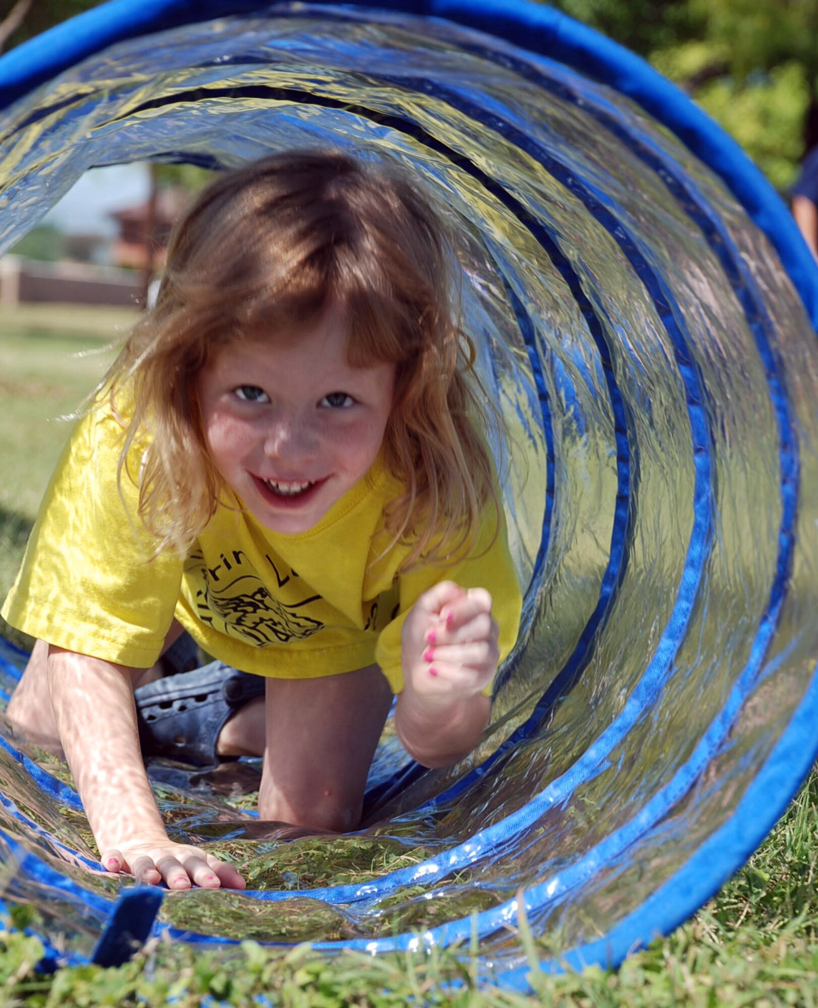 LAUGHLIN AIR FORCE BASE, Texas – Carly Schans, 5, daughter of Sonya and Col. Martin Schans, 47th Operations Group commander, climbs through a tunnel set up at Laughlin’s Child Development Center here May 28. The Health and Wellness Center held a “Fun Day” at the CDC in honor of May being Air Force Fitness Month. The “Fun Day” included fitness activities for children from age two to five-years-old. (U.S. Air Force photo by Tech. Sgt. Joel Langton)