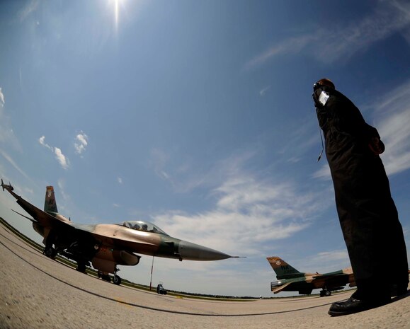 Senior Airman Jason Patterson, an F-16 Fighting Falcon Aggressor crew chief, assigned to the 57th Aircraft Maintenance Squadron, Nellis Air Force Base, Nev., prepare to marshal out Capt. Patrick Bagan, assigned to the 64th Aggressor Squadron during exercise Maple Flag 42 at 4 Wing Cold Lake, Canada, June 2. Maple Flag is a Canadian-sponsored and Air Combat Command supported exercise, that provides aircrews simulated air and ground combat training to coalition forces in a NATO environment.(U.S. Air Force Photo/Senior Airman Larry E. Reid Jr., Released)