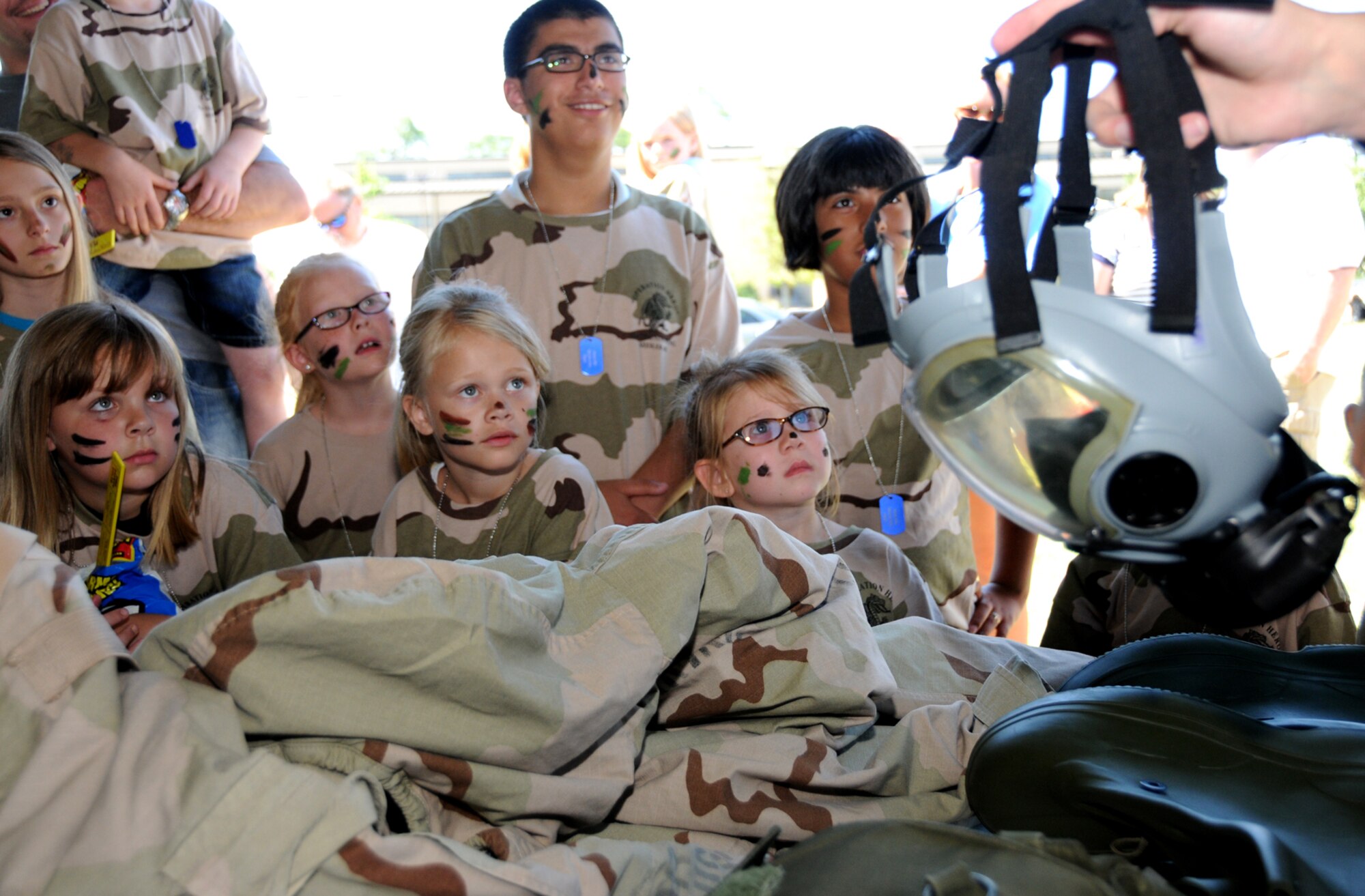 Left, Young Dragons learn about gas masks, gear, and clothing items required at deployed locations.  (U.S. Air Force photo by Kemberly Groue)