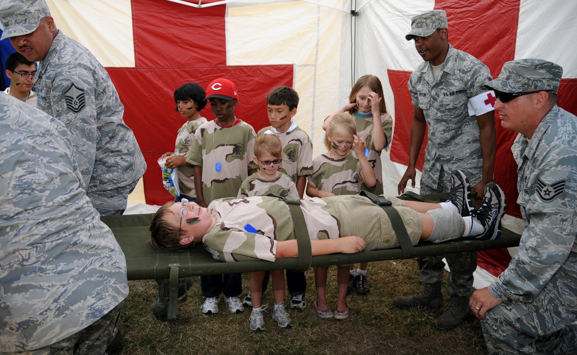 From left, Master Sgt. Lerry Forester, 81st Medical Support Squadron; Airman 1st Class Robert Tipton, 81st Medical Operations Squadron, and Staff Sgt. William Smitko, 81st MDSS, carry 10-year-old Cameron Arthur on a stretcher as they demonstrate self-aid and buddy care techniques during Saturday’s Operation Hero.  The program, hosted by the airman and family readiness center, introduces children to the deployment experience.  Cameron’s parents are Master Sgt. George and Laura Arthur, 81st Mission Support Group.  (U.S. Air Force photo by Kemberly Groue)