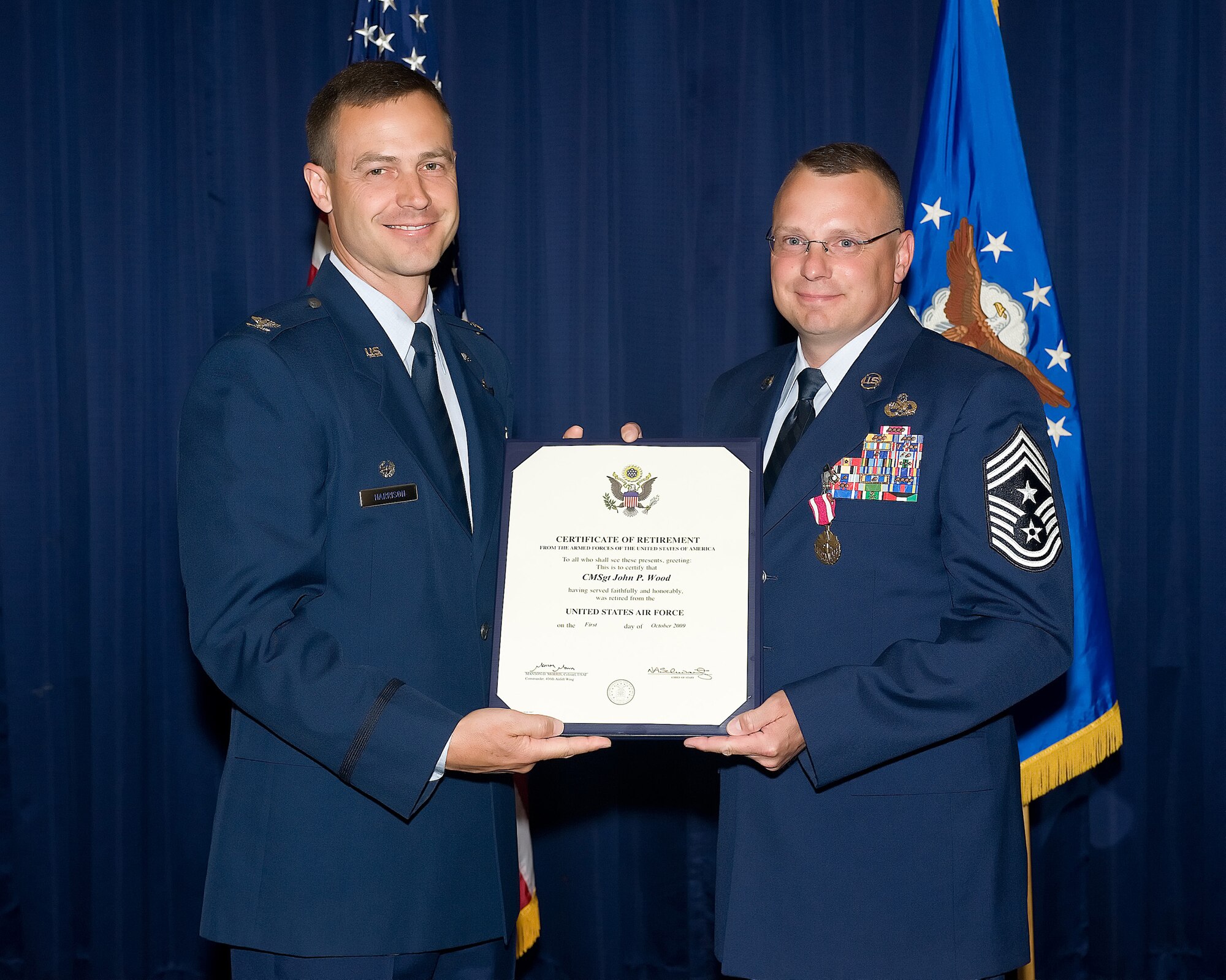 (Left) Col. Steven Harrison, 89th Airlift Wing commander, presents a retirement certificate to Chief Master Sgt. John Wood, 436th Airlift Wing command chief, at The Landings Club May 28. Before retiring, Chief Wood handed over the reins of command chief for the Eagle Wing to Chief Master Sgt. Daniel Chadwick, 436th Airlift Wing interim command chief. (U.S. Air Force photo/Jason Minto)