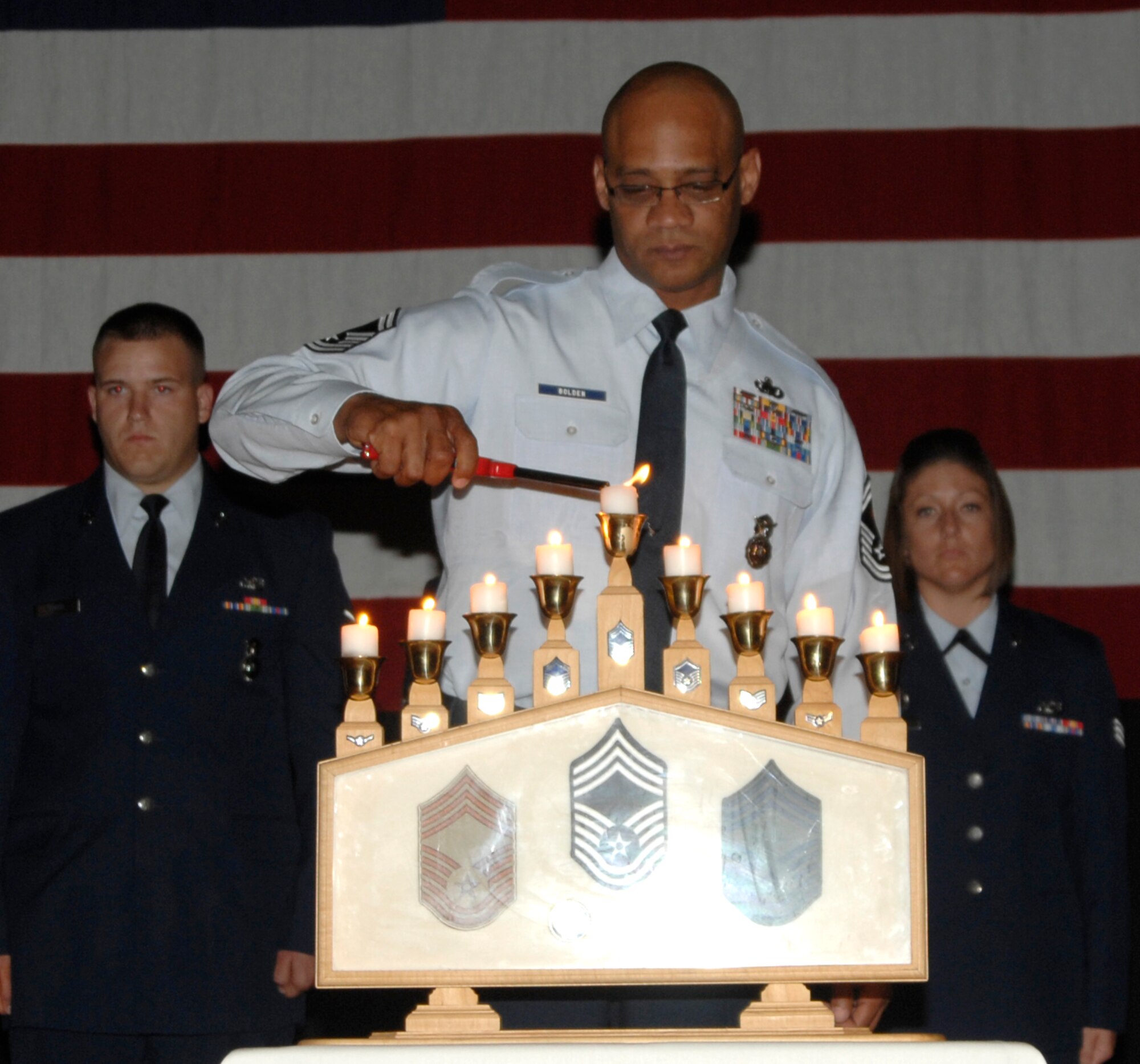MCCONNELL AIR FORCE BASE, Kan. -- Chief Master Sgt. Michael Bolden, 22nd Security Forces Squadron, lights a candle commemorating his step up to chief during the wing promotion ceremony in the Robert J. Dole Community Center ballroom, May 28. Chiefs and senior master sergeants make up 3.5 percent of the enlisted force. Lighting the candles signifies moving up from each rank to attain the highest enlisted status as chief. (Photo by Senior Airman Laura Suttles)