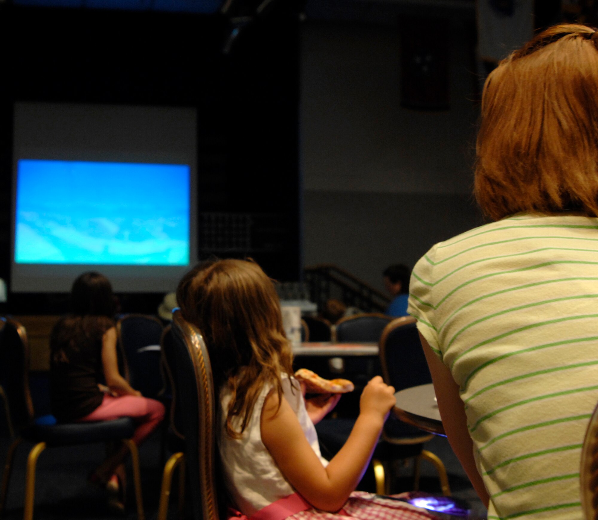 MCCONNELL AIR FORCE, Kan. -- Tech. Sgt. Genevieve Morris, 22nd Air Refueling Wing Public Affairs, watches a movie with her daughter Sarah, 4, in the Robert J. Dole Community Center ballroom, during family night, May 29. Family night consists of bingo, movies, food, and coloring for kids for a small fee of $5 per person. (Photo by Senior Airman Laura Suttles)