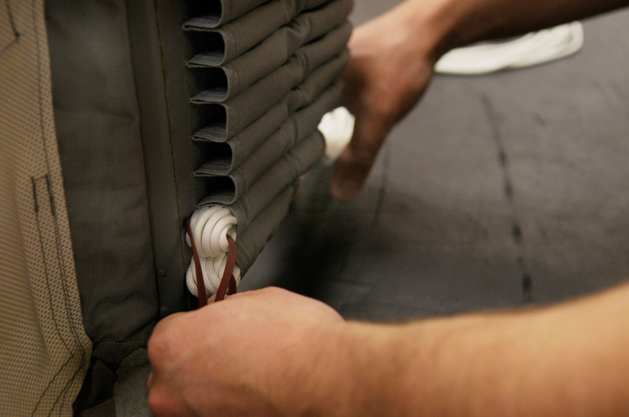 Senior Airman David Fraser carefully inspects a suspension line which is placed into the flutes of the parachute May 29, 2009, Eielson Air Force Base, Alaska. Life support staff ensure the pilots equipment is in working condition prior to them stepping. Airman Fraser is an aircrew flight equipment technician with the 354th Operations Support Squadron.  (U.S. Air Force photo/Airman 1st Class Laura Max)