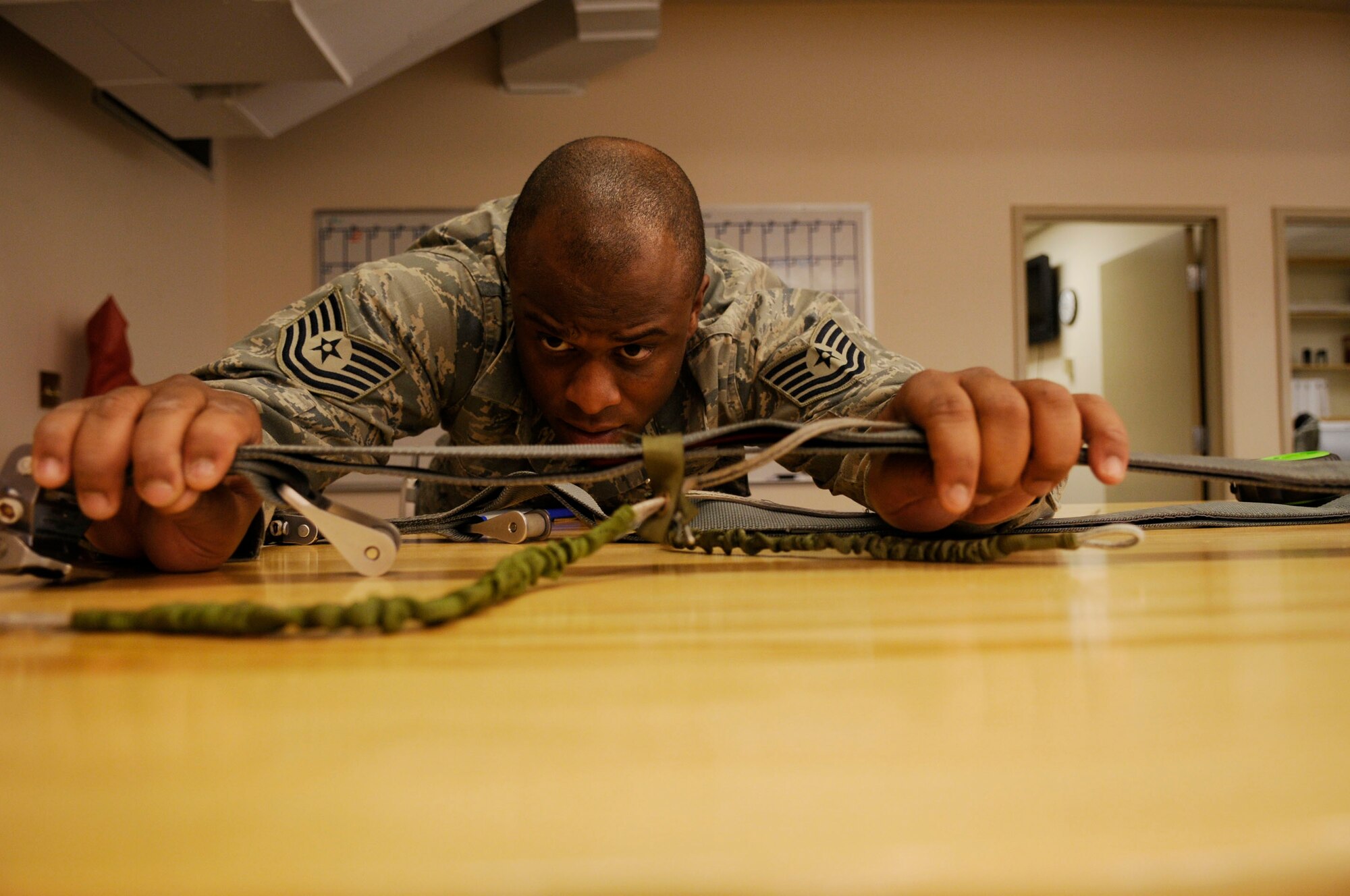 Tech. Sgt Crosby Newbill inspects the harness slack of the parachute May 26, 2009, Eielson Air Force Base, Alaska.  Life support staff ensure the pilots equipment is in working condition prior to them stepping. Sergeant Newbill is an aircrew flight equipment NCOIC with the 354th Operations Support Squadron. (U.S. Air Force photo/Airman 1st Class Laura Max)