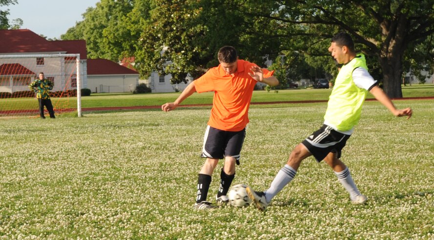 Jarret Pendl, 2d Munitions Squadron fights for the soccer ball with a 2d Logistics Squadron team member during a game at the Barksdale Fitness Center field, May 27. (United States Air Force photo by Senior Airman Alexandra Sandoval) (RELEASED)
