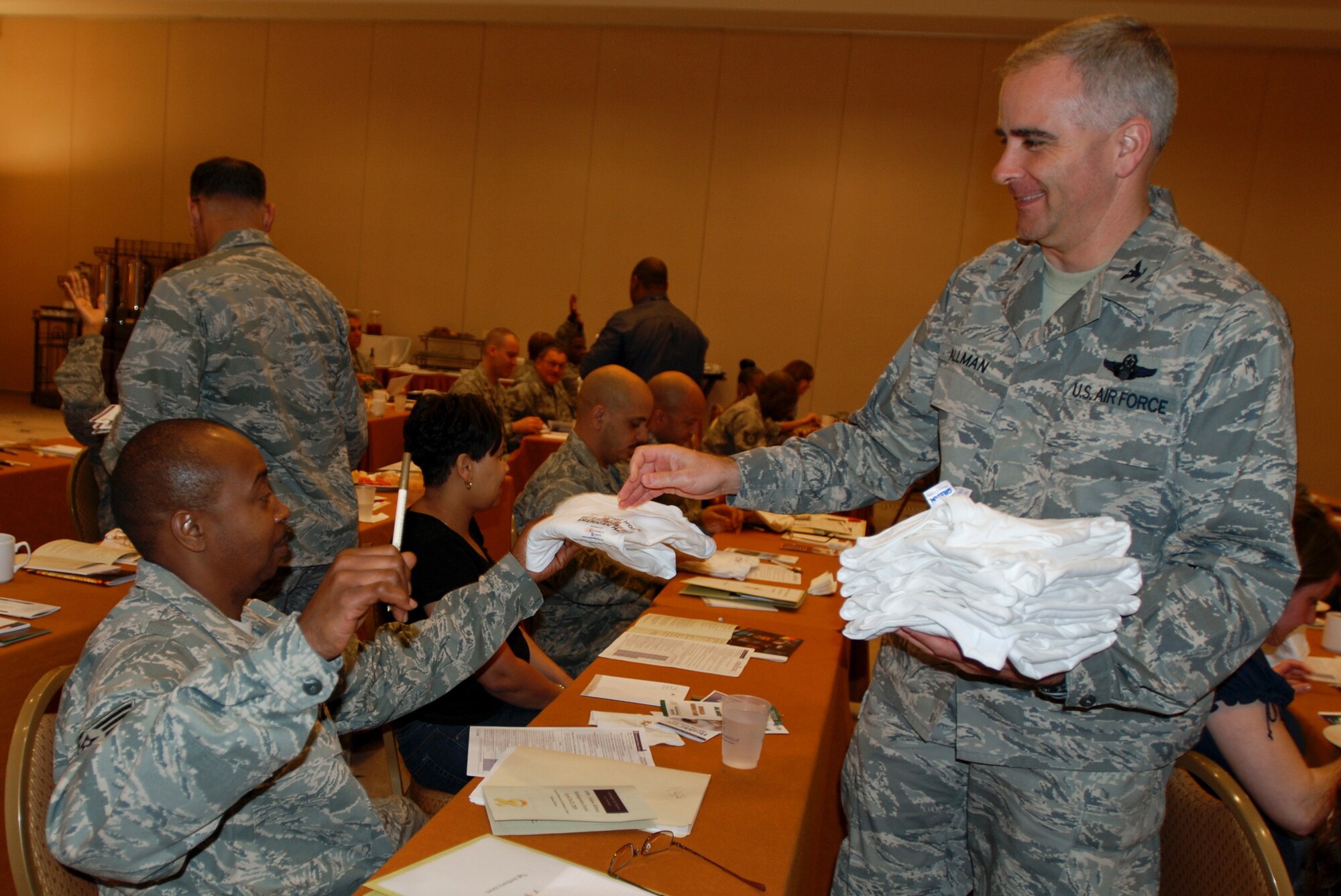 Colonel Mike Allman, vice commander of the 459th Air Refueling Wing, passes out Operation Iraqi Freedom shirts to 459th Reservists at the first 459th ARW Yellow Ribbon welcome home event.  The event, held at the Gaylord Hotel, was ope to reservists who recently returned from deployment. (U.S. Air Force Photo/ Senior Airman Sasha S. Skirne)
