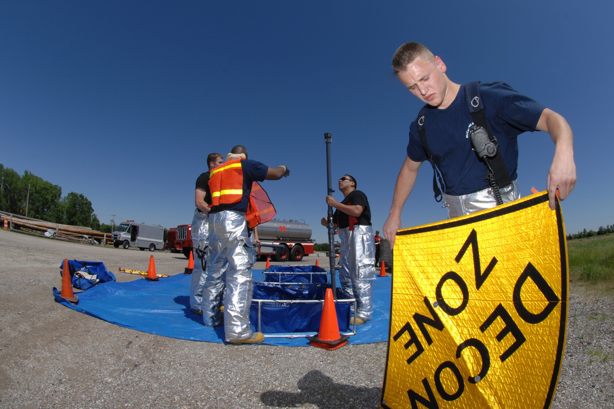 MCCONNELL AIR FORCE BASE, Kan. -- Airman William Turner, 22nd Civil Engineer Squadron, helps set up a decontamination area during an All Hazards Response training exercise on the base obstacle course, May 28. (Photo by Staff Sgt. Jamie Train)