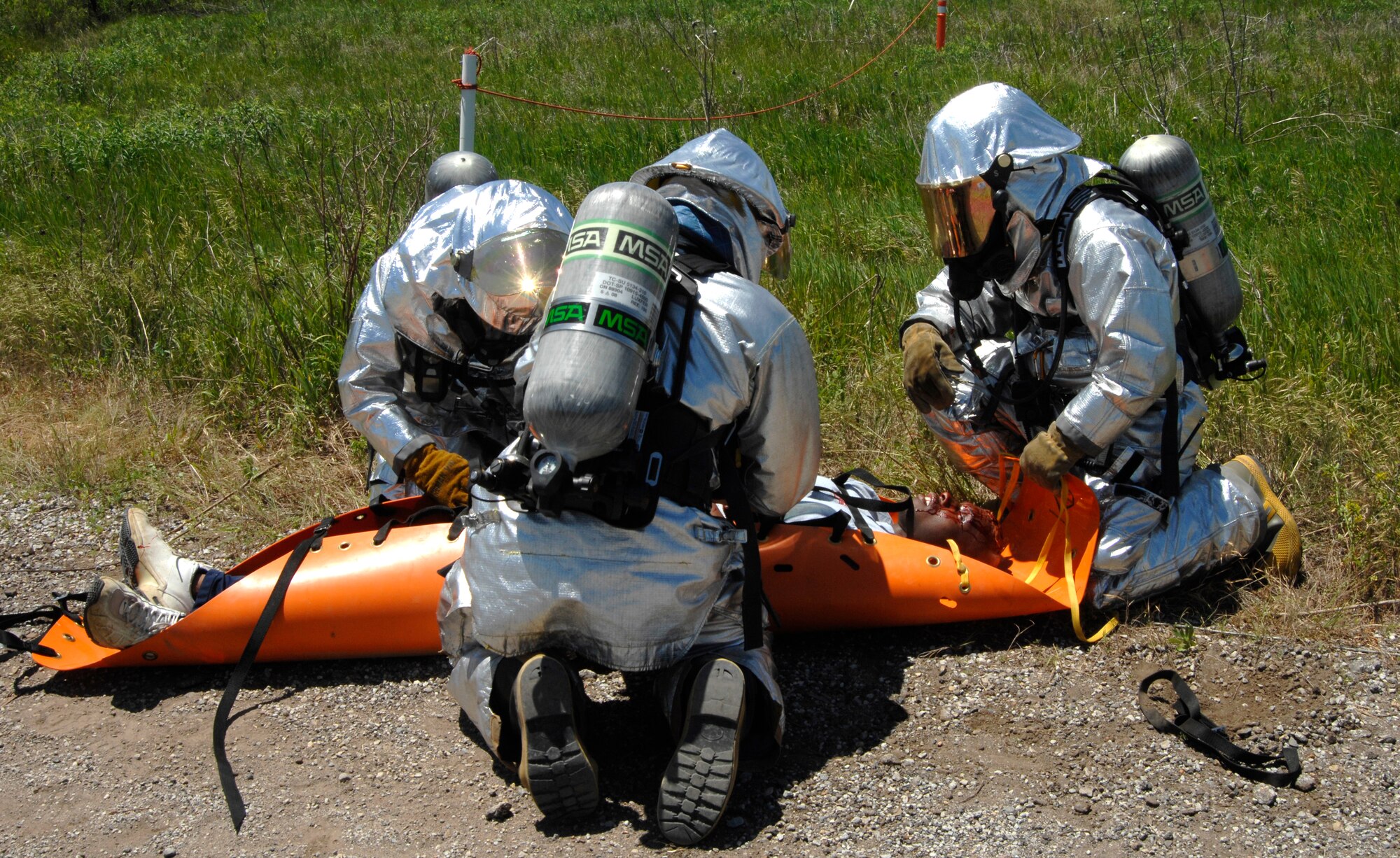 MCCONNELL AIR FORCE BASE, Kan. -- 22nd Civil Engineer Squadron firefighters, prepare to lift and transport 1st. Lt. Sean Mitchell, 384th Air Refueling Squadron, during an All Hazards Response training exercise at the base obstacle course, May 28. The McConnell firefighters were dispatched during the exercise to find and treat victims of a vehicle explosion. (Photo by Senior Airman Laura Suttles)