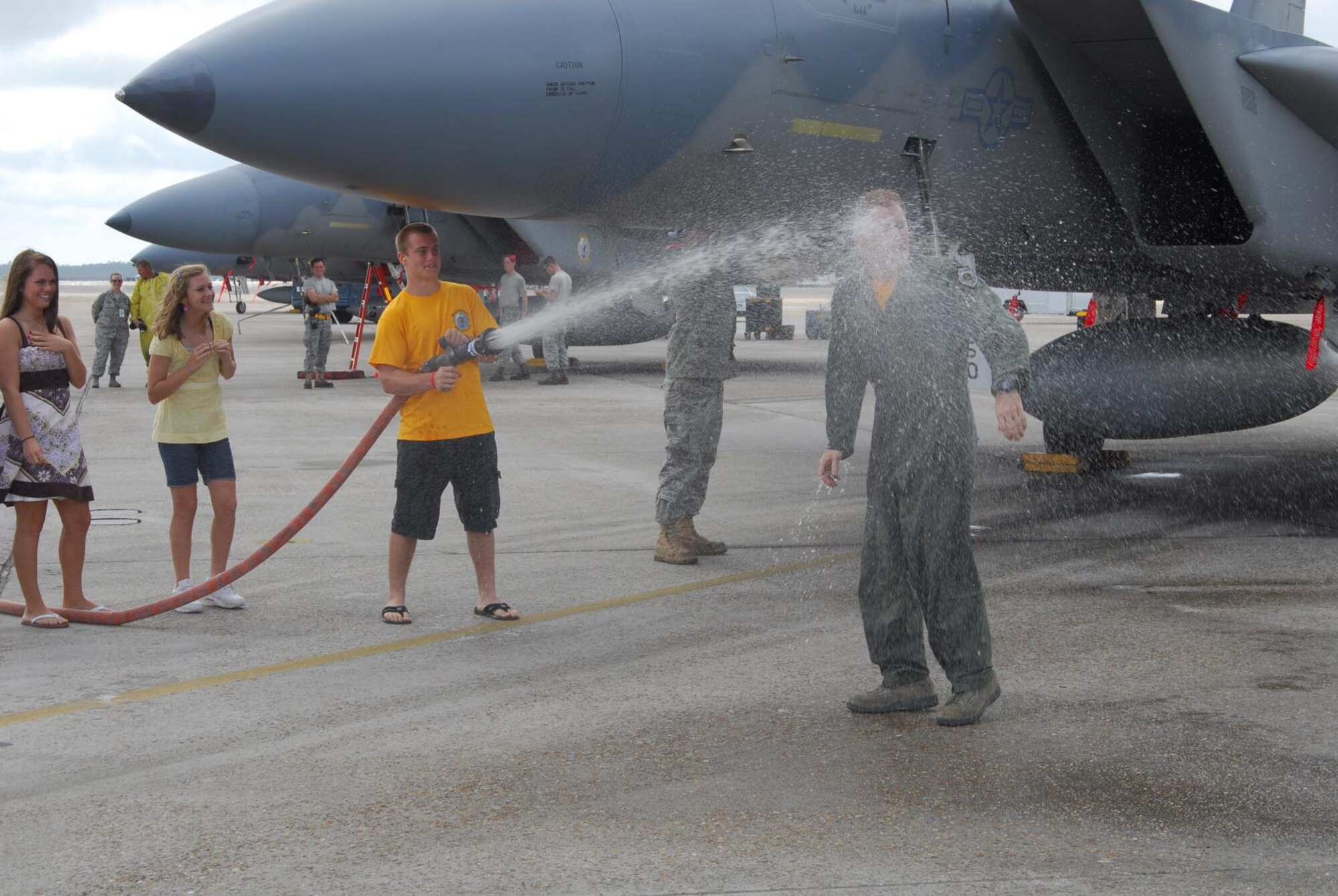 Col. David Kriner receives the traditional firehose spray-down by his son Emmett after his final flight in the F-15 Eagle.  U.S. Air Force photo by Lisa Norman.