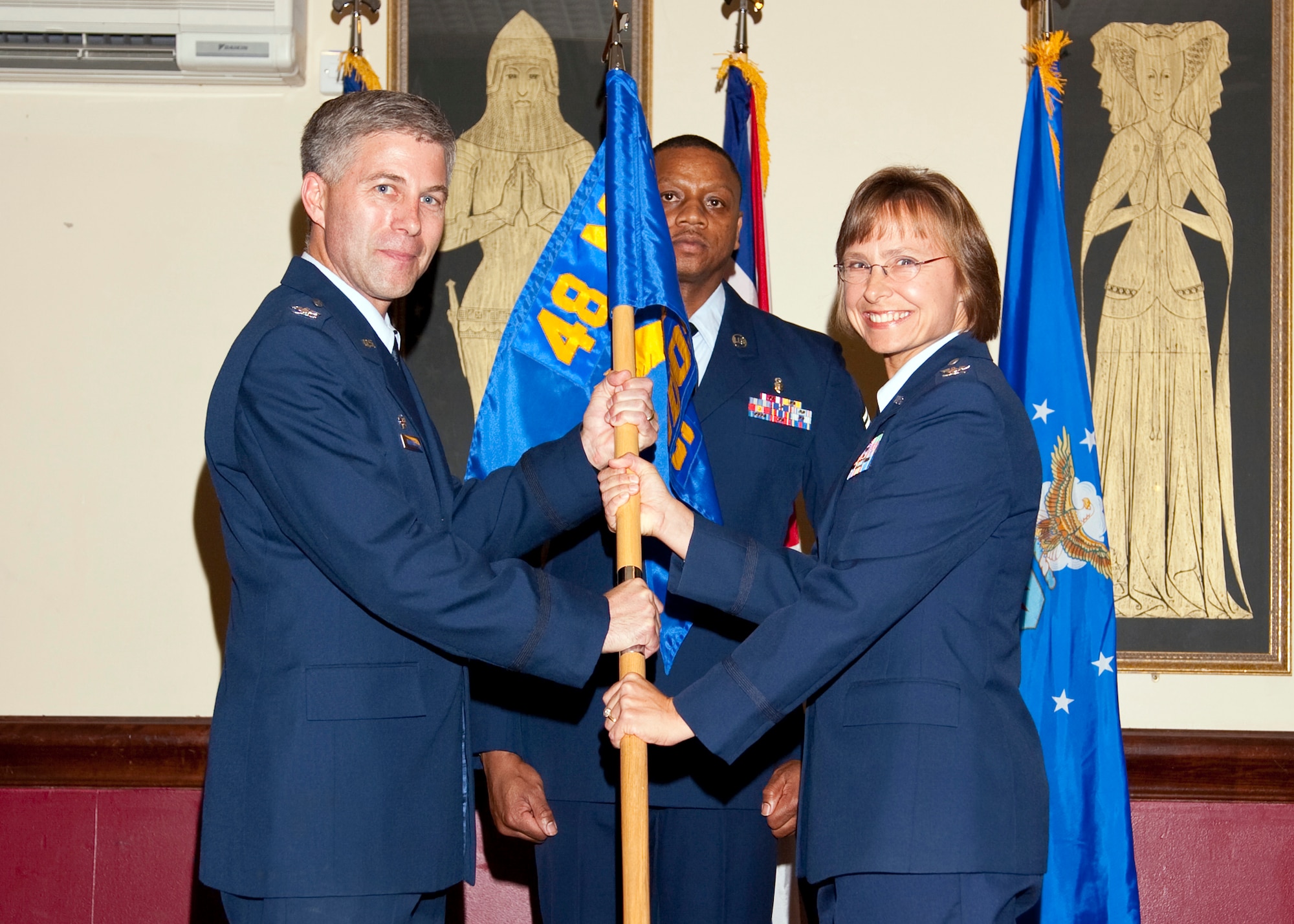 Col. Kenneth McDonnell, 48th Medical Group Commander, passes the 48th Medical Operations Squadron guidon to Col. Rebecca Brown as she takes command at Royal Air Force Lakenheath, England May 21, 2009. (Photo by Mr. Michael Mitchell)
