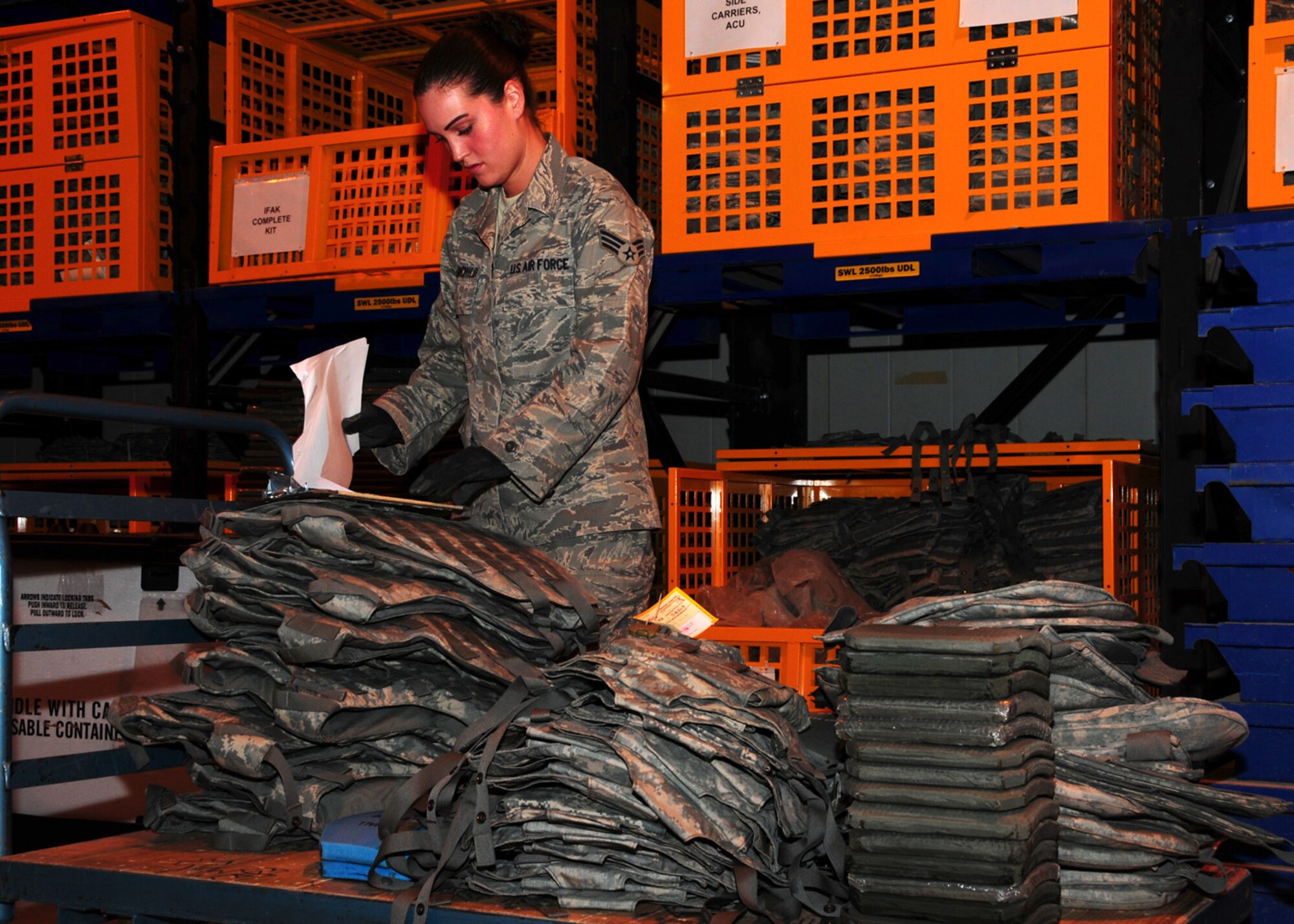 SOUTHWEST ASIA -- Senior Airman Jessica Fairchild, 386th Expeditionary Logistic Readiness Squadron, verifies against her list for the amount and size of body amour required at the 386th Expeditionary Theater Distribution Center at an air base in Southwest Asia, May 29. The ETDC issues IBA vests with plates, chemical warfare bags, cold weather gear, first aid kits and many other mobility items to reduce the amount of extra baggage the Airmen deploy with.  Airman Fairchild is deployed from Seymour Johnson Air Force Base, N.C. and is originally from Midland, Mich. (U.S. Air Force photo/ Senior Airman Courtney Richardson)