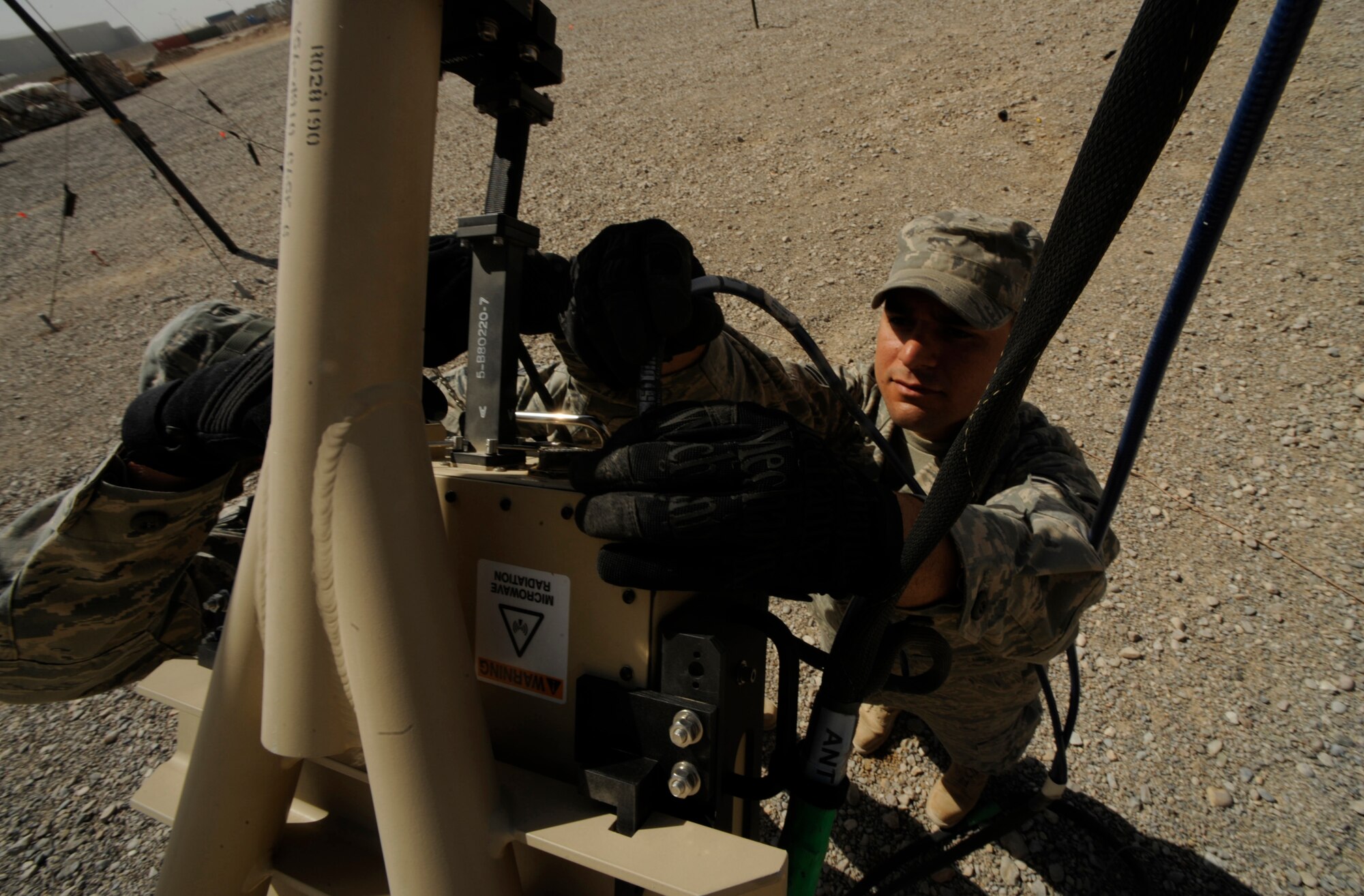 Senior Airman Sergio Saenz, RF transmissions engineer and satellite communications technician, 451st Combat Communications Squadron, 451st Air Expeditionary Group, Kandahar Airfield, Afghanistan, conducts routine maintenance on a satellite dish on May 17, 2009, in support of Operation Enduring Freedom.  Combat communications is responsible setting up and maintaining telephone and internet communications to more than 1,500 base users  (U.S. Air Force photo by Staff Sgt. James L. Harper Jr.)