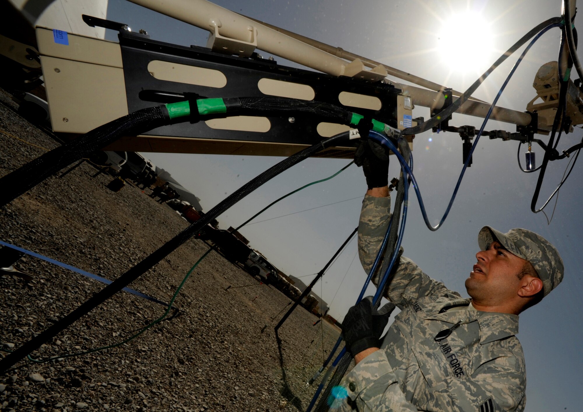 Senior Airman Sergio Saenz, RF transmissions engineer and satellite communications technician, 451st Combat Communications Squadron, 451st Air Expeditionary Group, Kandahar Airfield, Afghanistan, conducts routine maintenance on a satellite dish on May 17, 2009, in support of Operation Enduring Freedom.  Combat communications is responsible setting up and maintaining telephone and internet communications to more than 1500 base users  (U.S. Air Force photo by Staff Sgt. James L. Harper Jr.)