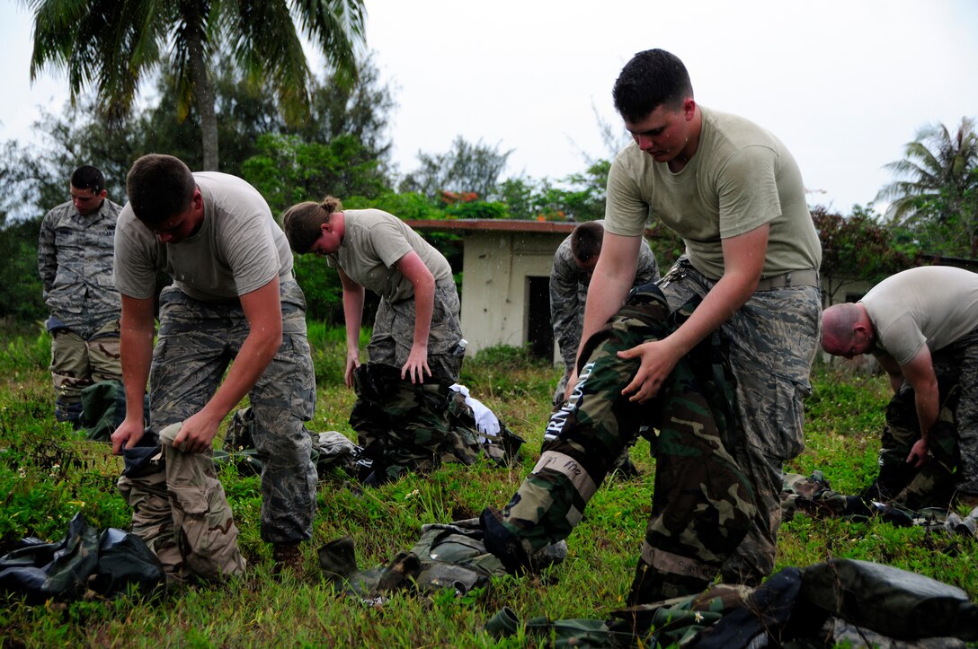 ANDERSEN AIR FORCE BASE, Guam - Members of the 36th Civil Engineer quickly don their mission oriented protective posture gear during a chemical, biological, radiological, nuclear, and (high-yield) explosives training course in conjunction with a field training exercise at Andersen South training facility June 3. Once the Airmen put on their MOPP 4 gear, instructors inspected them to ensure they were properly wearing their protective clothing. (U.S. Air Force photo by Airman 1st Class Courtney Witt)