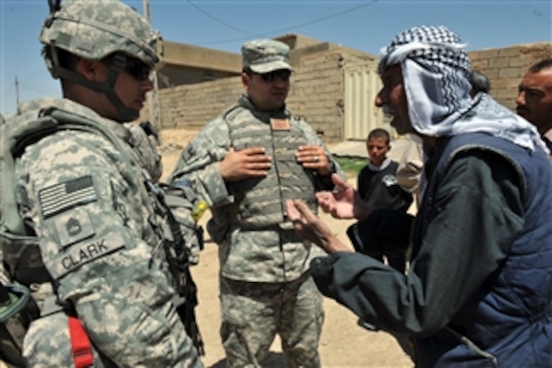 U.S. Army Sgt. 1st Class Bryon Clark (left) of Echo Company, 1st Battalion, 8th Cavalry Regiment, 2nd Heavy Brigade Combat Team, 1st Cavalry Division listens to an Iraqi farmer voicing his concerns in the village of Ka bashe in Kirkuk, Iraq, on May 31, 2009.  U.S. Coalition Forces partner with Iraqi police to inspect irrigation systems and meet with local farmers that have agricultural concerns in and around the Kirkuk Province of Iraq.  