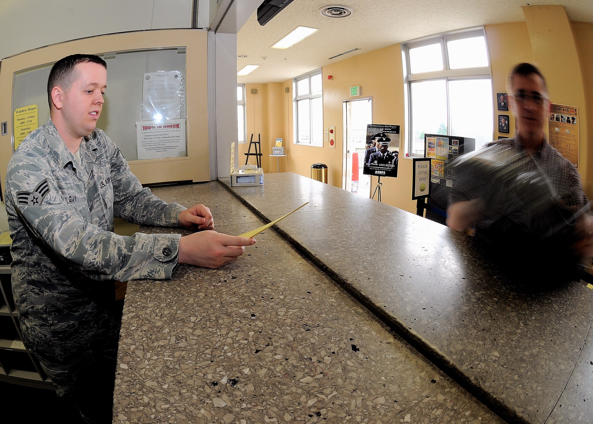 YOKOTA AIR BASE, Japan -- Senior Airman Adam Guy, 374th Communications Squadron, gives a customer his package at the post office June 4.The Yokota post office was awarded the 2008 Air Force Outstanding Large Postal Facility award. The unit was recognized for their environmentally friendly recycling program and security procedures. (U.S. Air Force photo/Airman 1st Class Michael Dillon)