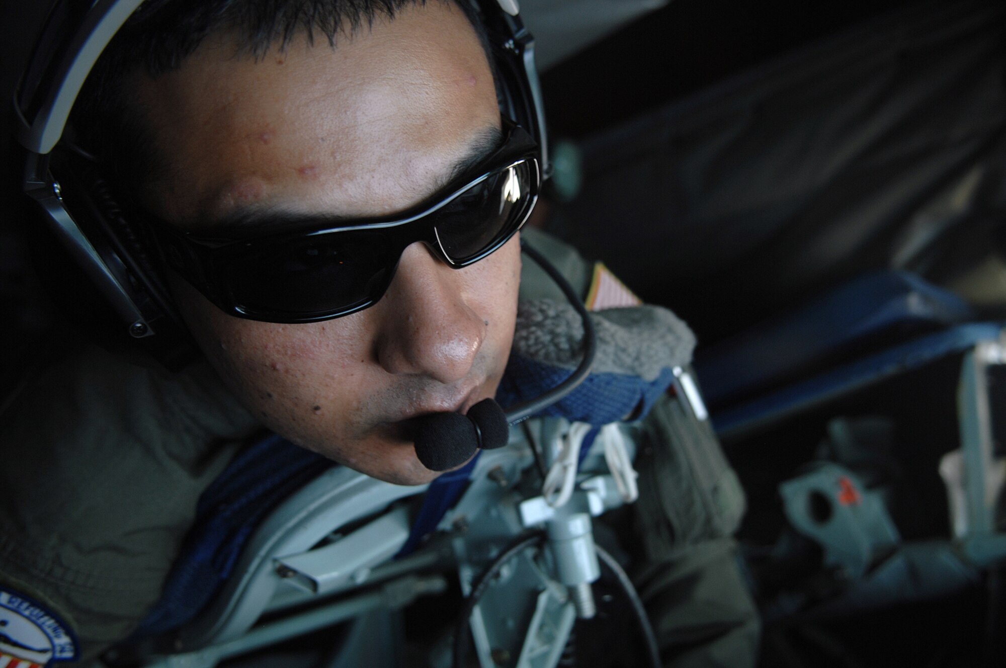 Technical Sgt. Osvaldo Castro, a boom operator with the 336th Air Refueling Squadron, looks out the boom pod of a KC-135R Stratotanker for the C-17A he will refuel over the Pacific Ocean during a training mission. (U.S. Air Force photo by Master Sgt Rick Sforza)