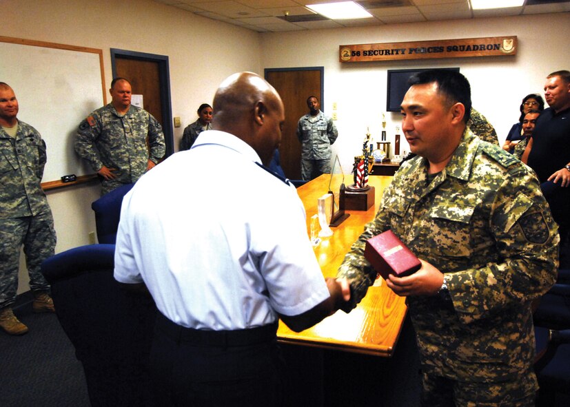 Col. Andre Curry, 56th Mission Support Group commander, receives a gift from members of a visiting contingent from Kazakhstan before they were briefed on the security forces mission at Luke. (U.S. Air Force photo/ Tech. Sgt. Jeffery Wolfe)