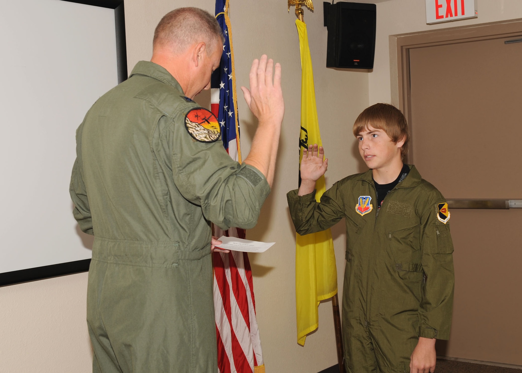 Lt. Col. Thomas Cheatham, 355th Operations Group deputy commander, administers the oath of enlistment to Evan Dusek, 14, during his visit here May 29. The Pilot for a Day program is designed to help children with disabilities or serious illnesses enjoy a day focused on them and their interest in aviation. (U.S. Air Force photo/Airman 1st Class Brittany Dowdle)