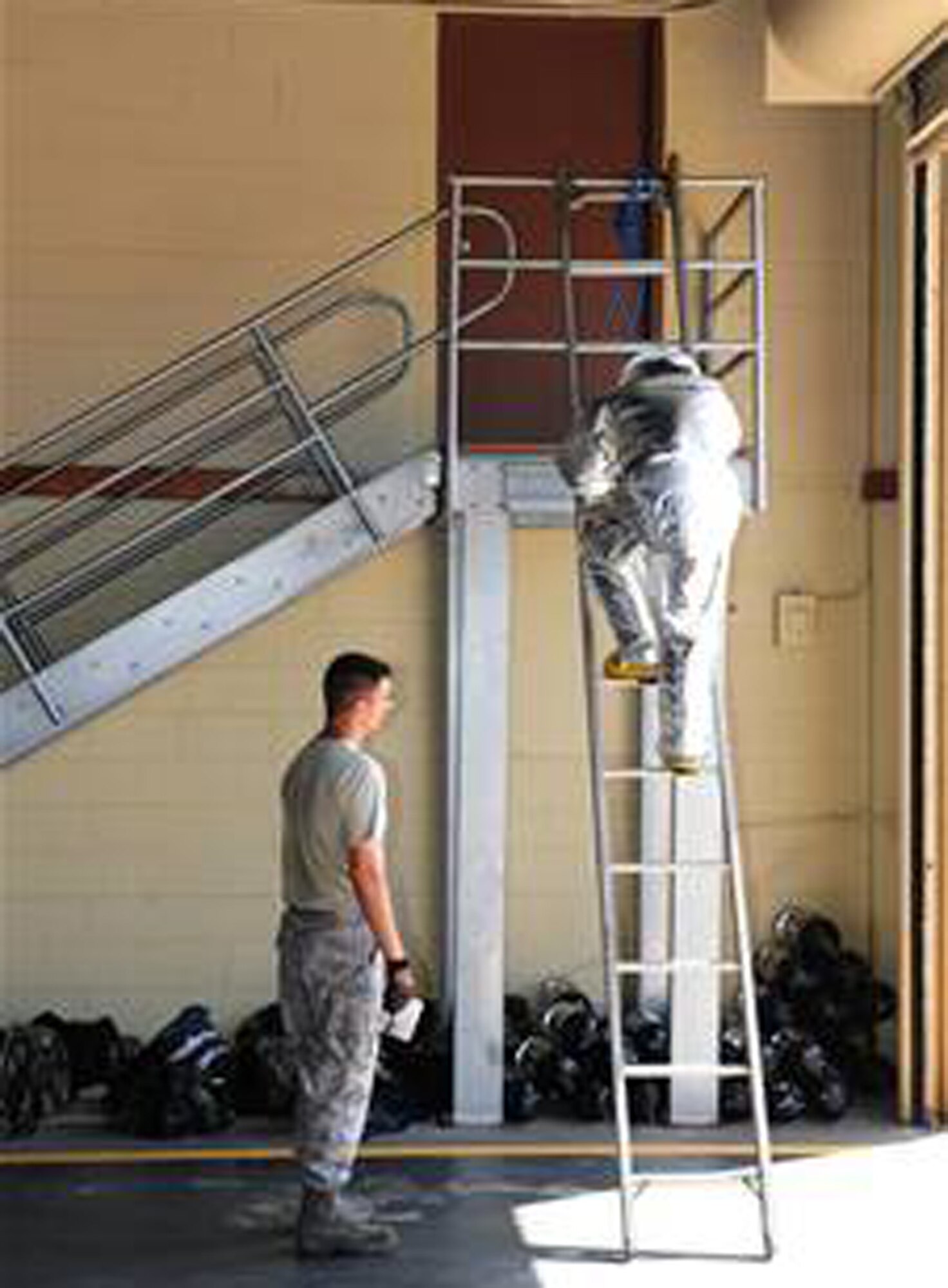 Staff Sgt. Dan Flick counts the steps as a U.S. Air Force Academy cadet runs up an eight-step ladder three times in a firefighter physical training competition May 19 at Andersen Air Force Base, Guam. The fire house offered a unique perspective for the third-year cadets as the cadets observed enlisted personnel in action in leadership positions. Sergeant Flick is assigned to the 36th Civil Engineer Squadron fire department. (U.S. Air Force photo/Tech. Sgt. Michael Boquette)
