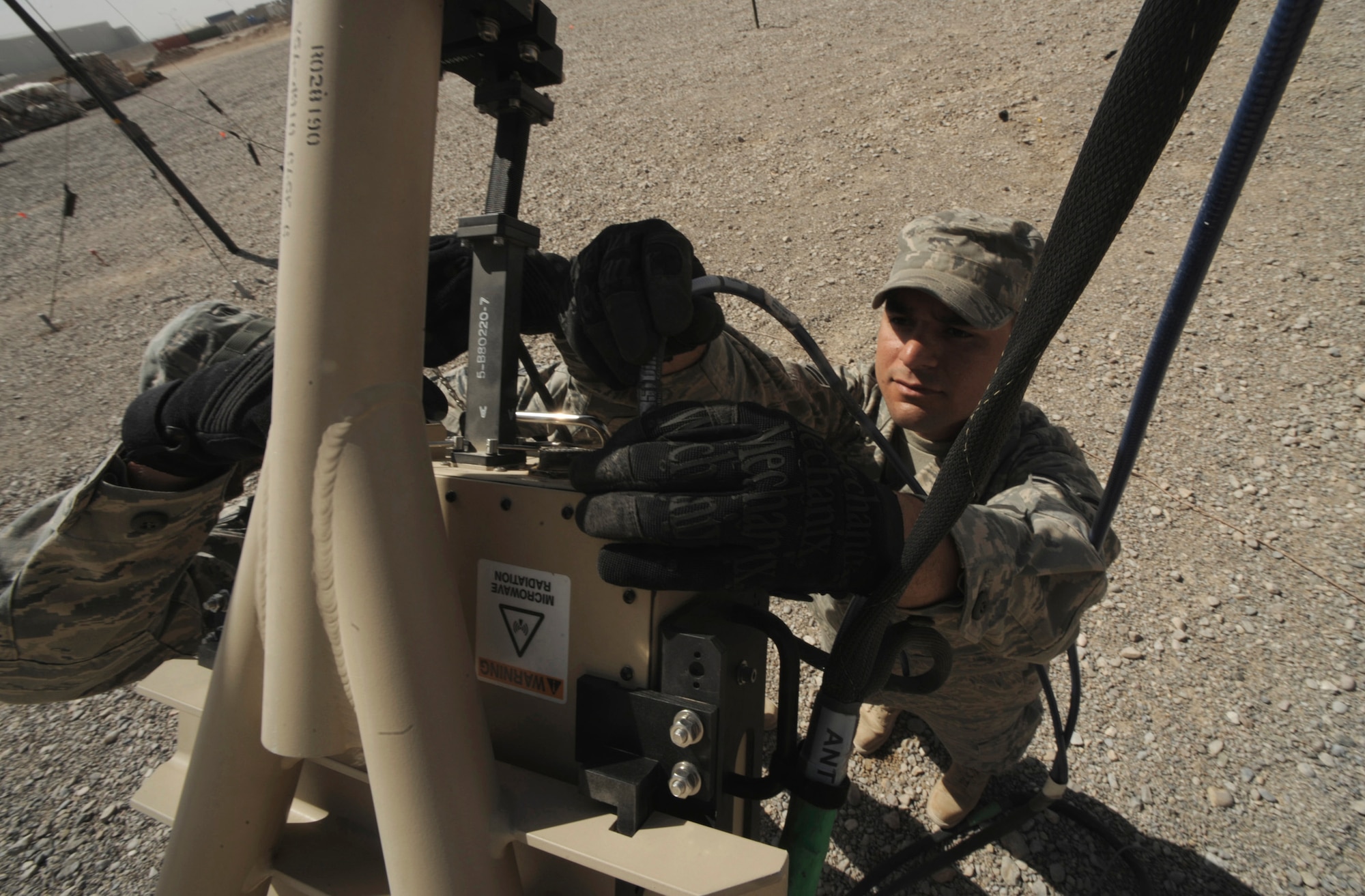 Senior Airman Sergio Saenz performs routine maintenance May 17 on a satellite dish at Kandahar Airfield, Afghanistan. Combat communications Airmen are responsible setting up and maintaining base telephone and internet communications.  Airman Saenz is an RF transmissions engineer and satellite communications technician with the 451st Combat Communications Squadron at Kandahar.   (U.S. Air Force photo/Staff Sgt. James L. Harper Jr.)
