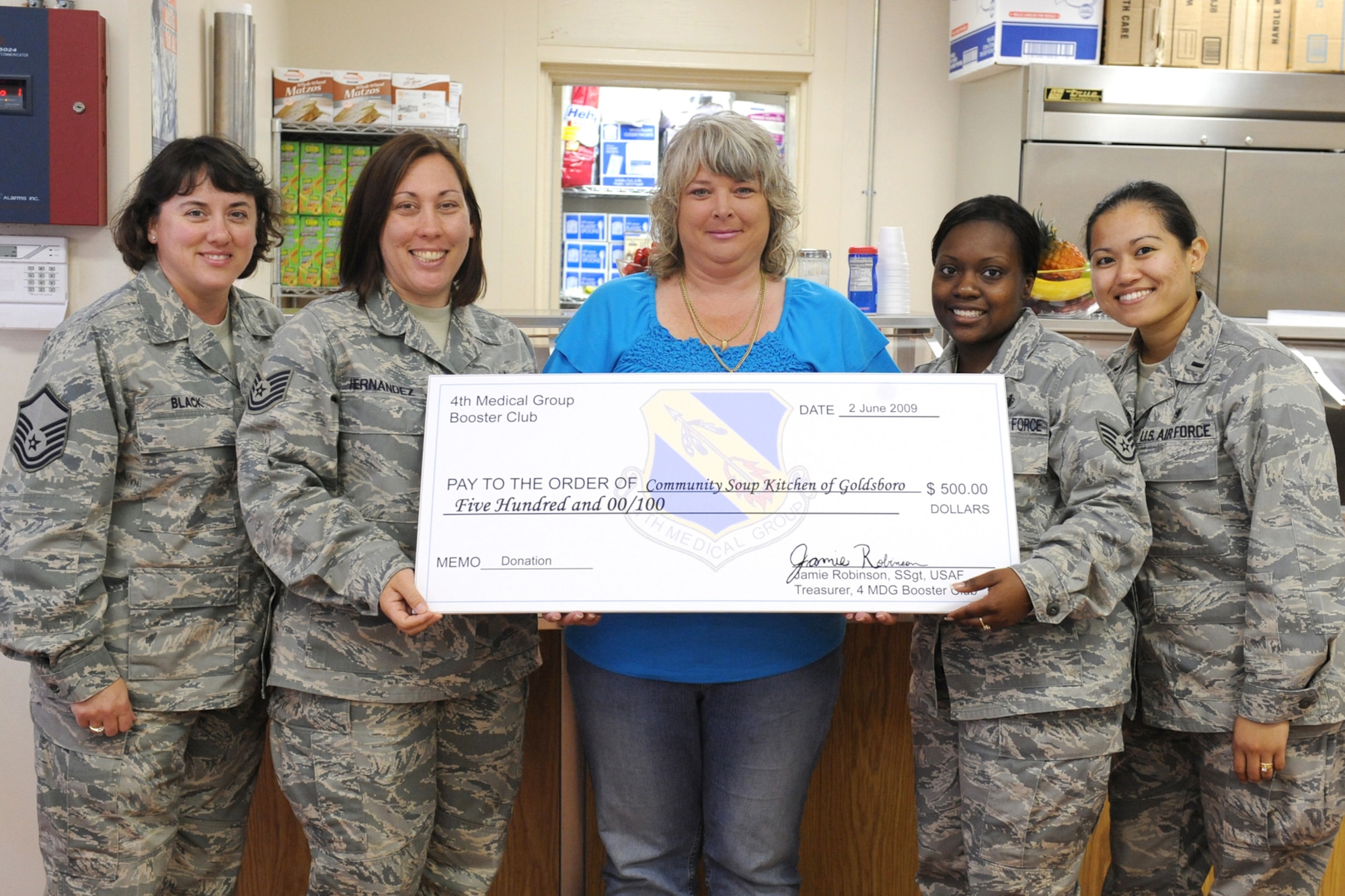 Airmen from the 4th Medical Group donate a $500 check to the Community Soup Kitchen of Goldsboro N.C., June 2, 2009. The soup kitchen provides free meals to homeless and people in need in the local community. The kitchen has served over 736,220 meals for the hungry in Wayne County since 1980. (U.S. Air Force photo by Airman 1st Class Whitney S. Lambert)