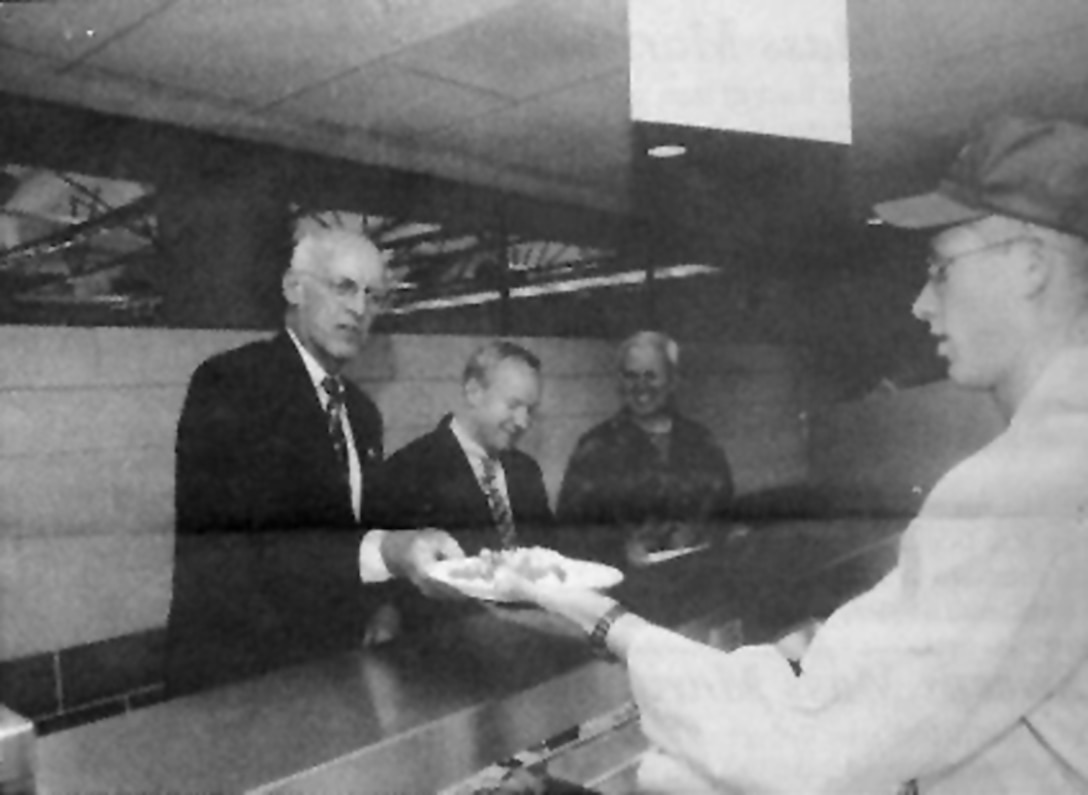 Congressman John Oliver receiving the first plate of food from Tech. Sgt. Jay Salus at the Dining Facility grand opening