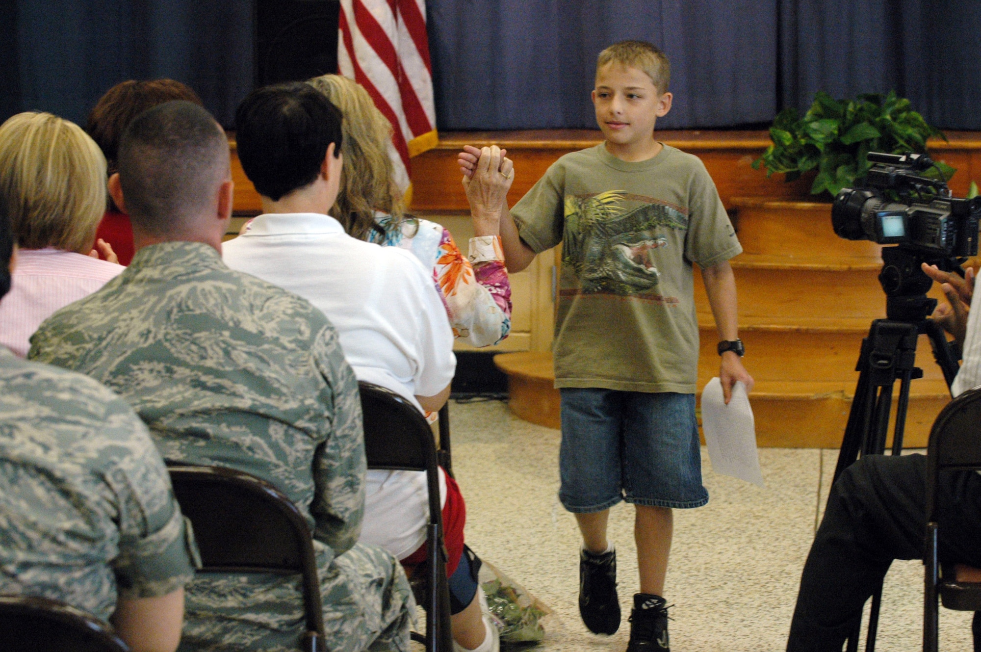 Drew Schuler gets an approving high five from Dr. Elaine Beraza, DDESS Director, after giving a speech on "What Robins Elementary means to me" at the Robins Elementary Closing Ceremony May 29. Schuler is the only student to have completed every grade from pre- kindergarten to sixth grade. U. S. Air Force photo by Sue Sapp