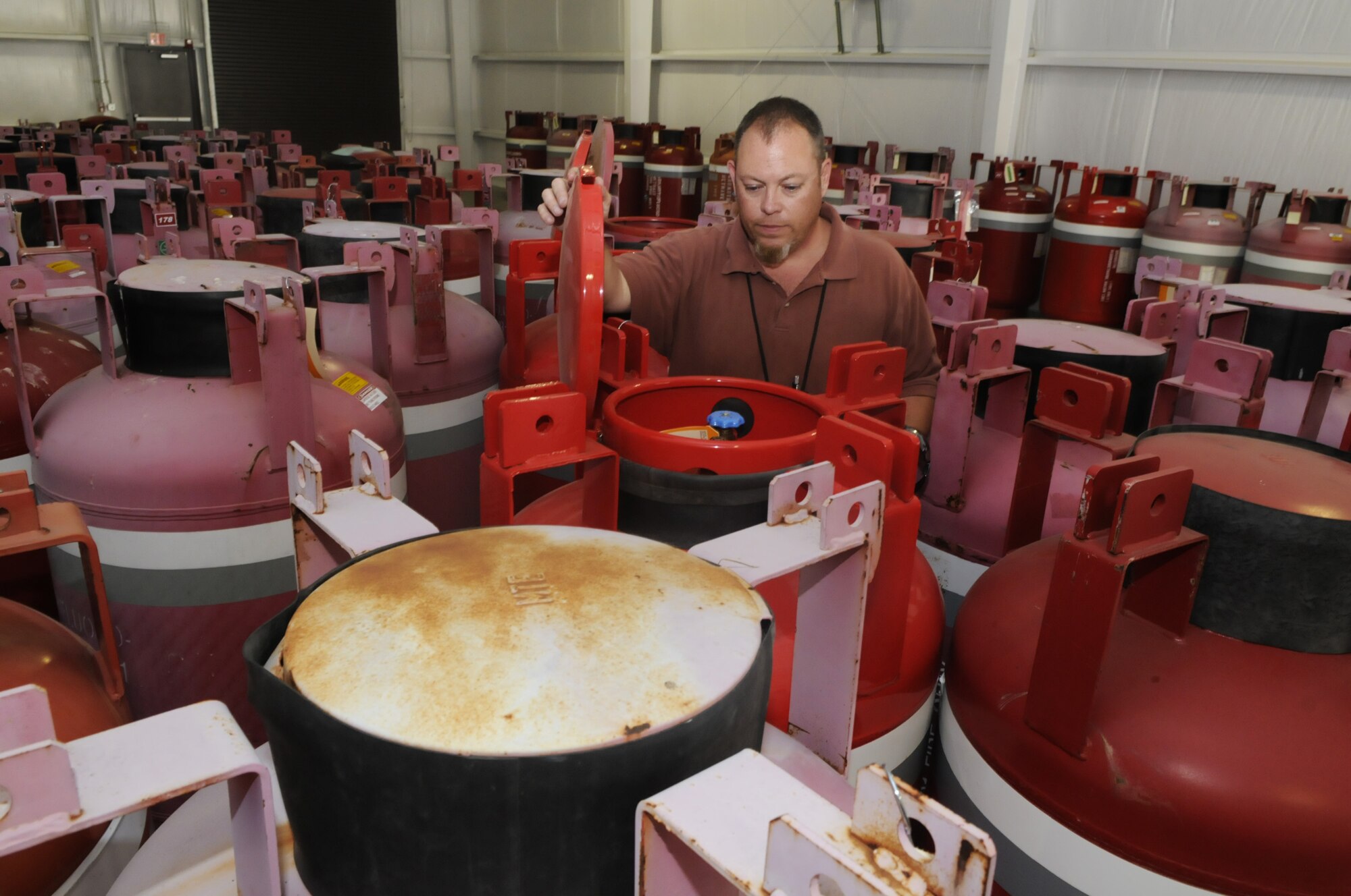 Todd Hurlburt checks on the storage containers of halon that will be reused. U. S. Air Force photo by Sue Sapp