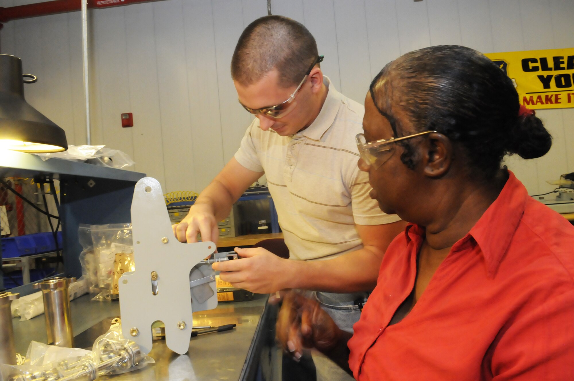 Mark Windham and Rosa Jordan, pneudraulics systems mechanics, work on a C-130 air cargo door uplock. U. S. Air Force photo by Sue Sapp