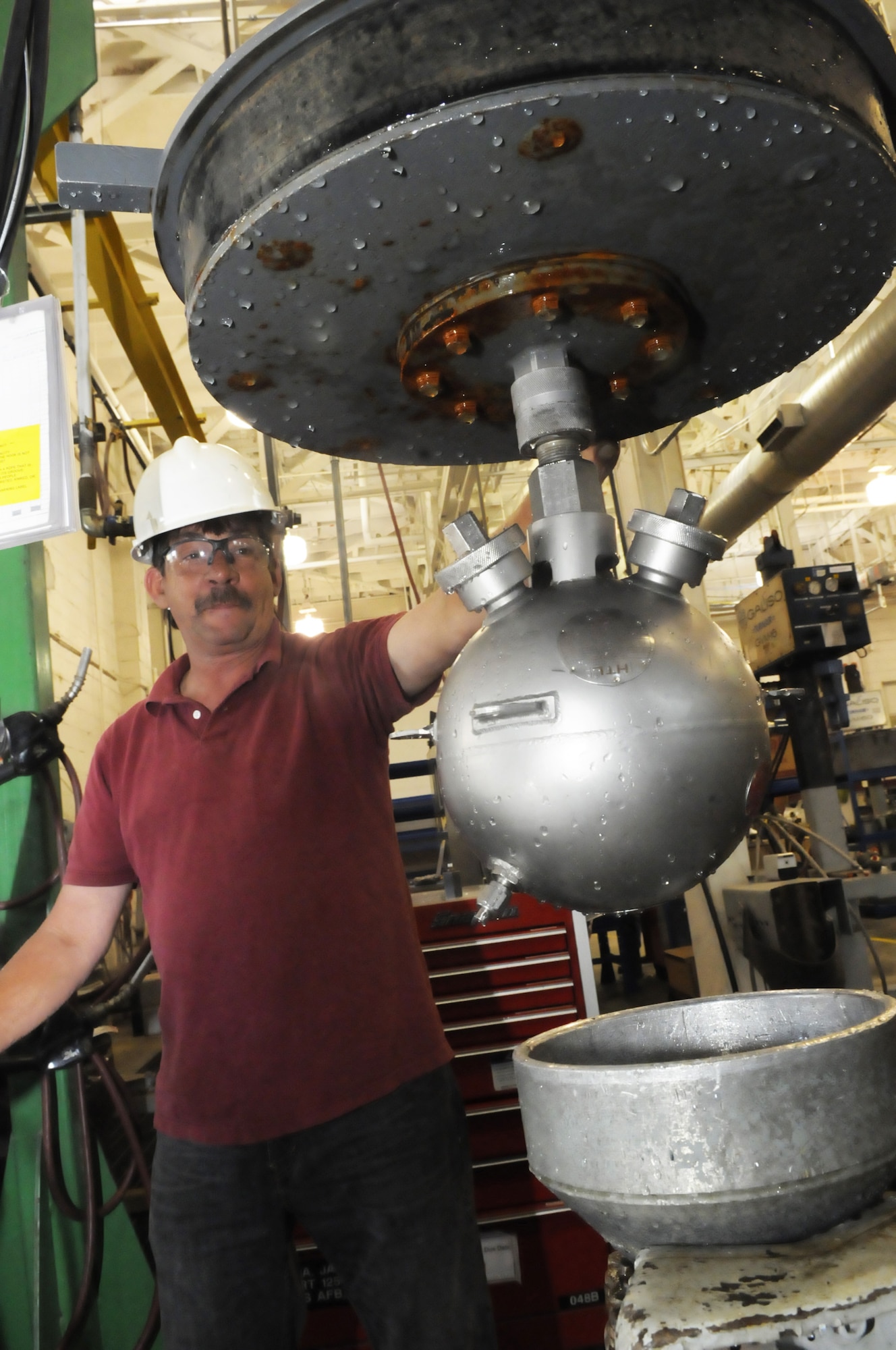 Frank Jackson, pneudraulics systems mechanic, performs a hydro test on an A-10 engine fire extinquisherby placing it in water and applying 1800 lbs of pressure to make sure it has no cracks. U. S. Air Force photo by Sue Sapp