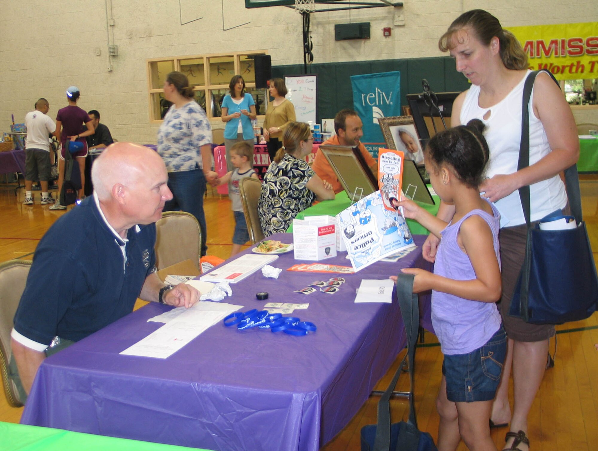 MSgt Melissa Lewis and her daughter Lyndsey learn about practicing safe bicycle riding techniques at Kid’s Fit Fest on Saturday, May 30. More than 100 parents and children visited the Health Fair. The Fit Fest began with the Armed Forces Kids Run at the Fitness Center track for children ages five to 13. The Fit Fest continued with a Health Fair for the children and their parents in the Fitness Center Gym. There were inflatables, informational booths, healthy snacks, and various sports demonstrations. (U.S. Air Force photo by Melissa Seror). 