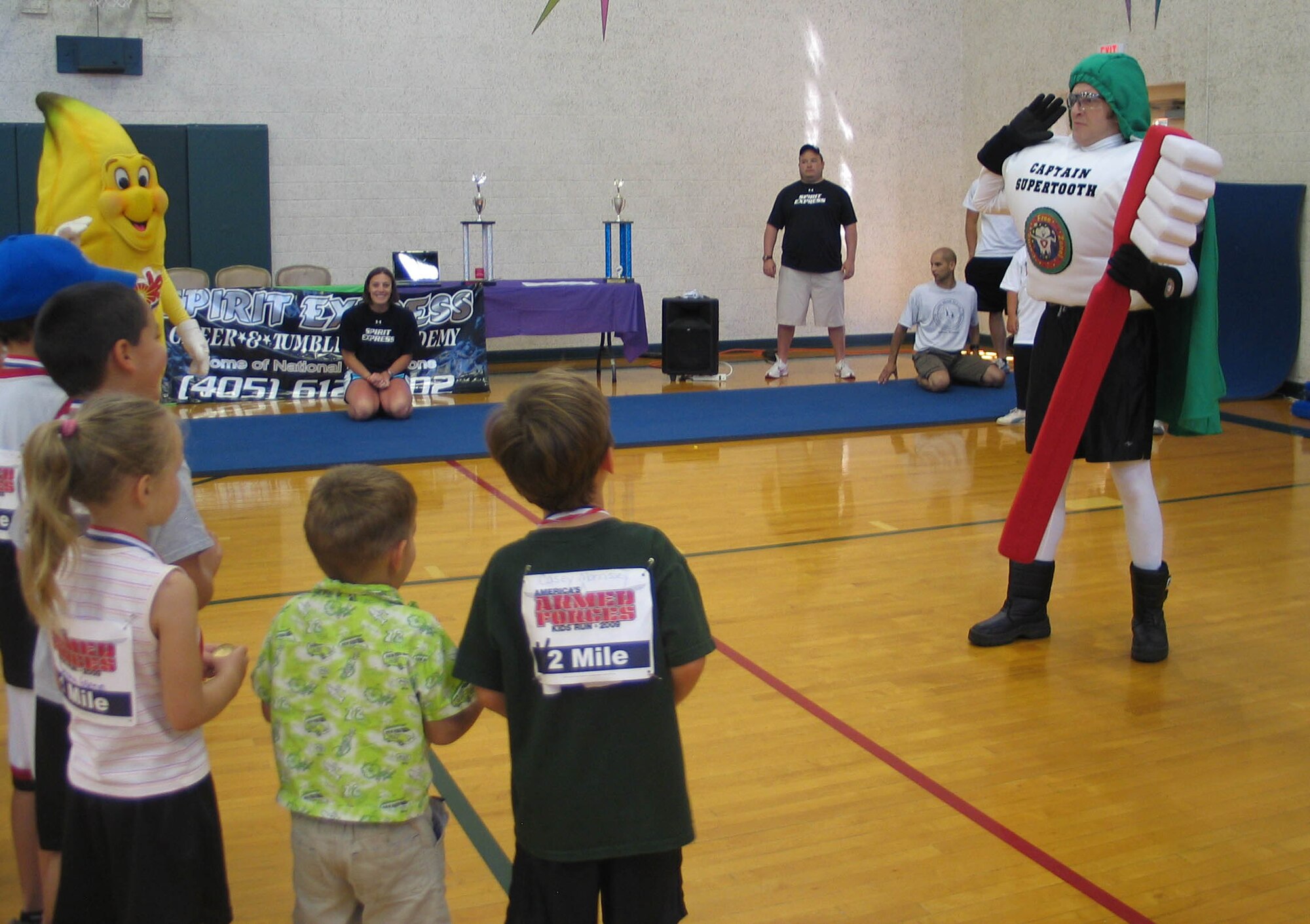 Captain Supertooth from the 71st Dental Group teaches Vance youth the importance of brushing their teeth at the Kid’s Fit Fest on Saturday, May 30. More than 100 parents and children visited the Health Fair. The Fit Fest began with the Armed Forces Kids Run at the Fitness Center track for children ages five to 13. The Fit Fest continued with a Health Fair for the children and their parents in the Fitness Center Gym. There were inflatables, informational booths, healthy snacks, and various sports demonstrations. (U.S. Air Force photo by Melissa Seror). 