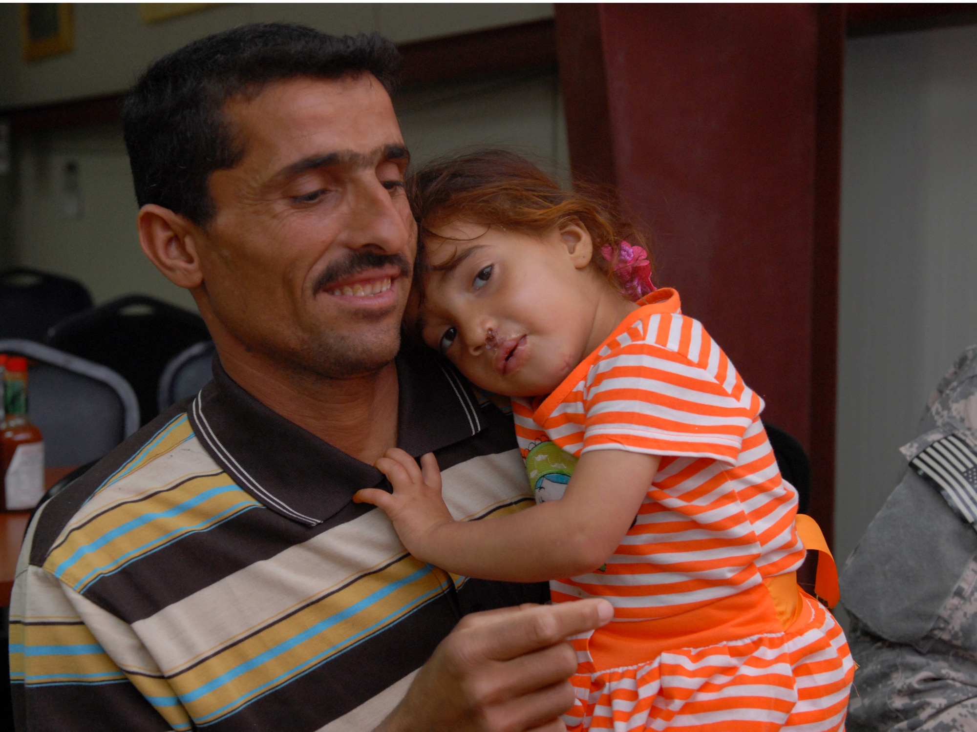 Juma Flalih Husayn and his daughter Zaenab, 2, share a moment before preparing for the trip home at Joint Base Balad, Iraq, May 2.  Zaenab recently underwent cleft lip and palate reconstruction at the Air Force Theatre Hospital, April 29. "A lot of kids with deformities get shunned, and that affects them for the rest of their life," said Air Force Lt. Col. Douglas Gottschalk, the otolaryngologist of Air Force Theatre Hospital. "A one day surgery [we performed], that's going to affect her for the rest of her life. That's a major thing." (U.S. Army photo by Sgt. Carl N. Hudson)