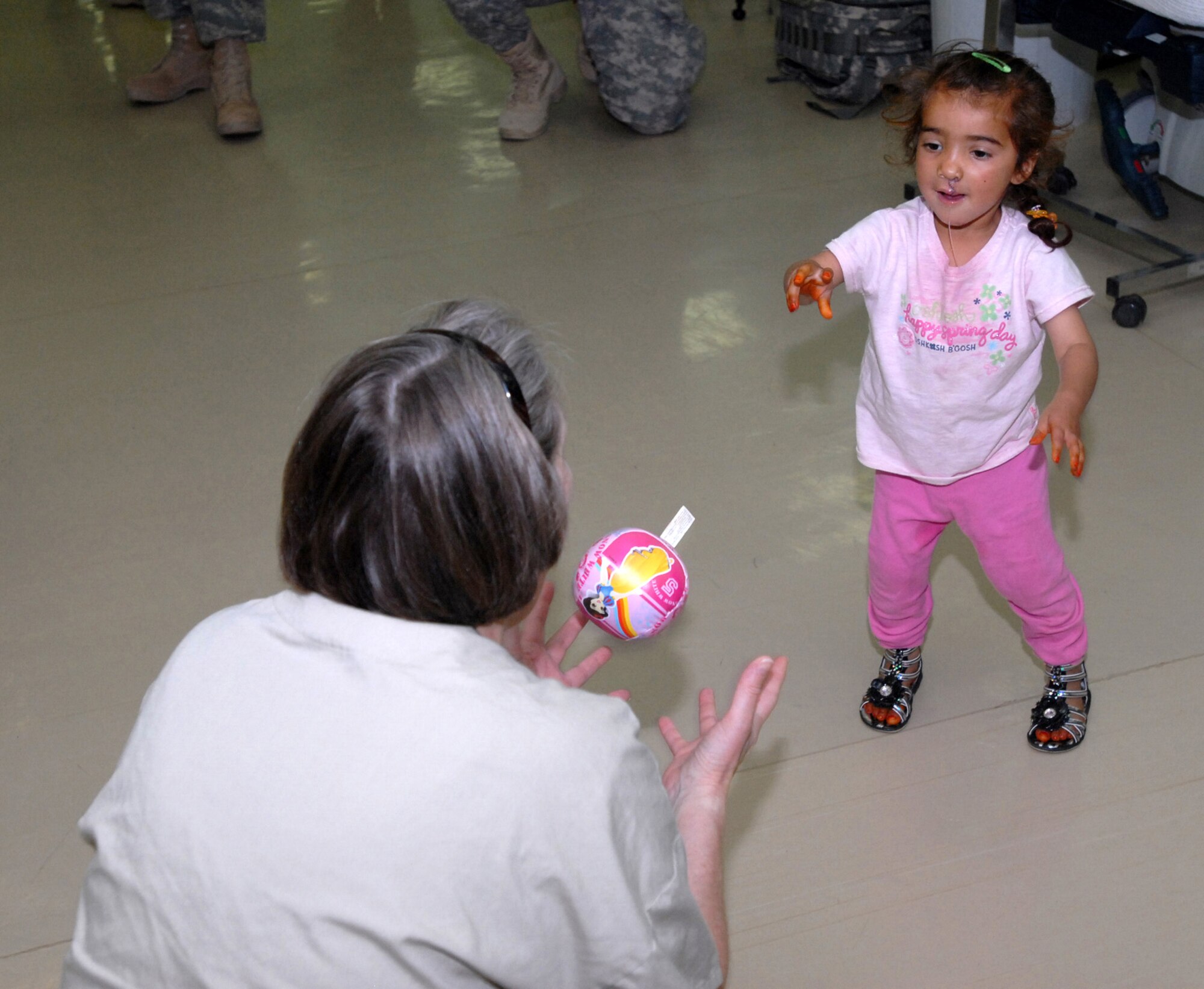 Zaenab, 2, plays a game of catch with Air Force Capt. Tamara Myers, a nurse in Air Force Theatre Hospital, in Joint Base Balad, Iraq, April 29. Zaenab recently underwent cleft lip and palate reconstruction after her village spoke with Coalition forces during a clinical assessment. "Coalition forces were in the area giving donations and helping the poor," said Juma Flalih Husayn, Zaenab's father. "I showed them my daughter." (U.S. Army photo by Sgt. Carl N. Hudson)