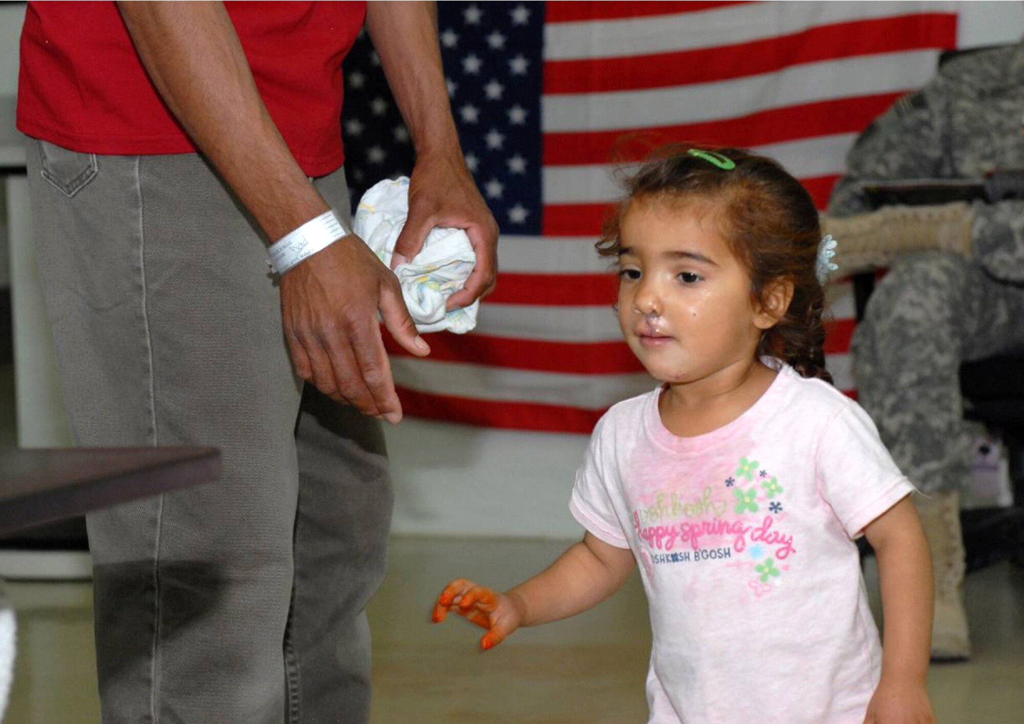 Zaenab, 2, runs to and from her father, Juma Flalih Husayn, after a successful cleft lip and palate operation at Air Force Theatre Hospital in Joint Base Balad, Iraq, April 29.  "We live for helping people," said Air Force Capt. Lee Brock, a pediatrician from the 332nd Expeditionary Medical Group. "In terms of cleft palate, this situation was not anything unusual.  What was unusual was the fact that we got to participate in helping her and we got to change her life in a lot of ways." (U.S. Army photo by Sgt. Carl N. Hudson)
