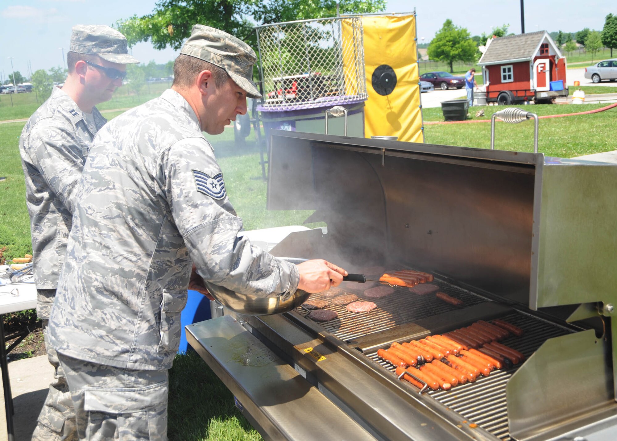 SCOTT AIR FORCE BASE, Ill. -- Capt. Tommy Fussell and Tech. Sgt. Mathew Alanza, 375th Airlift Wing Chapel, prepare hotdogs and hamburgers at the Dorm Olympics. (U.S. Air Force photo/Airman 1st Class Wesley Farnsworth)