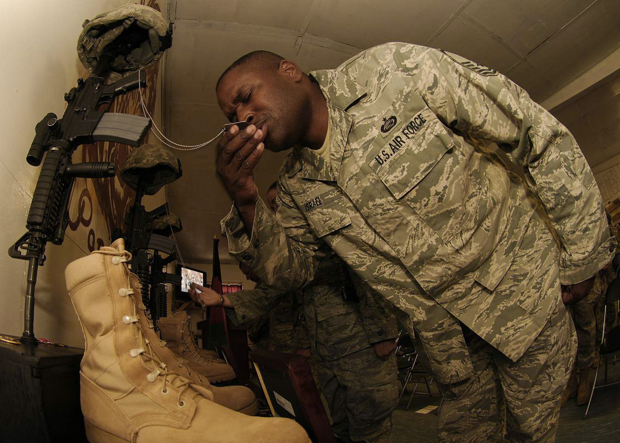 Master Sgt. Roderick Israel kisses the dog tags of Lt. Col. Mark Stratton during a May 31 memorial at Forward Operating Base Lion, Afghanistan. Colonel Stratton, the reconstruction team's commander, was killed along with three team members when their convoy vehicle was struck by a suicide car bomber May 26. The memorial also honored Army Master Sgt. Blue Rowe, the unit first sergeant, Senior Airman Ashton Goodman, a convoy driver, and Abdul Samad who served as the unit's local legal expert. Sergeant Israel is a member of the Panjshir Provincial Reconstruction Team. (U.S. Air Force photo/Staff Sgt. Jason Lake) 
