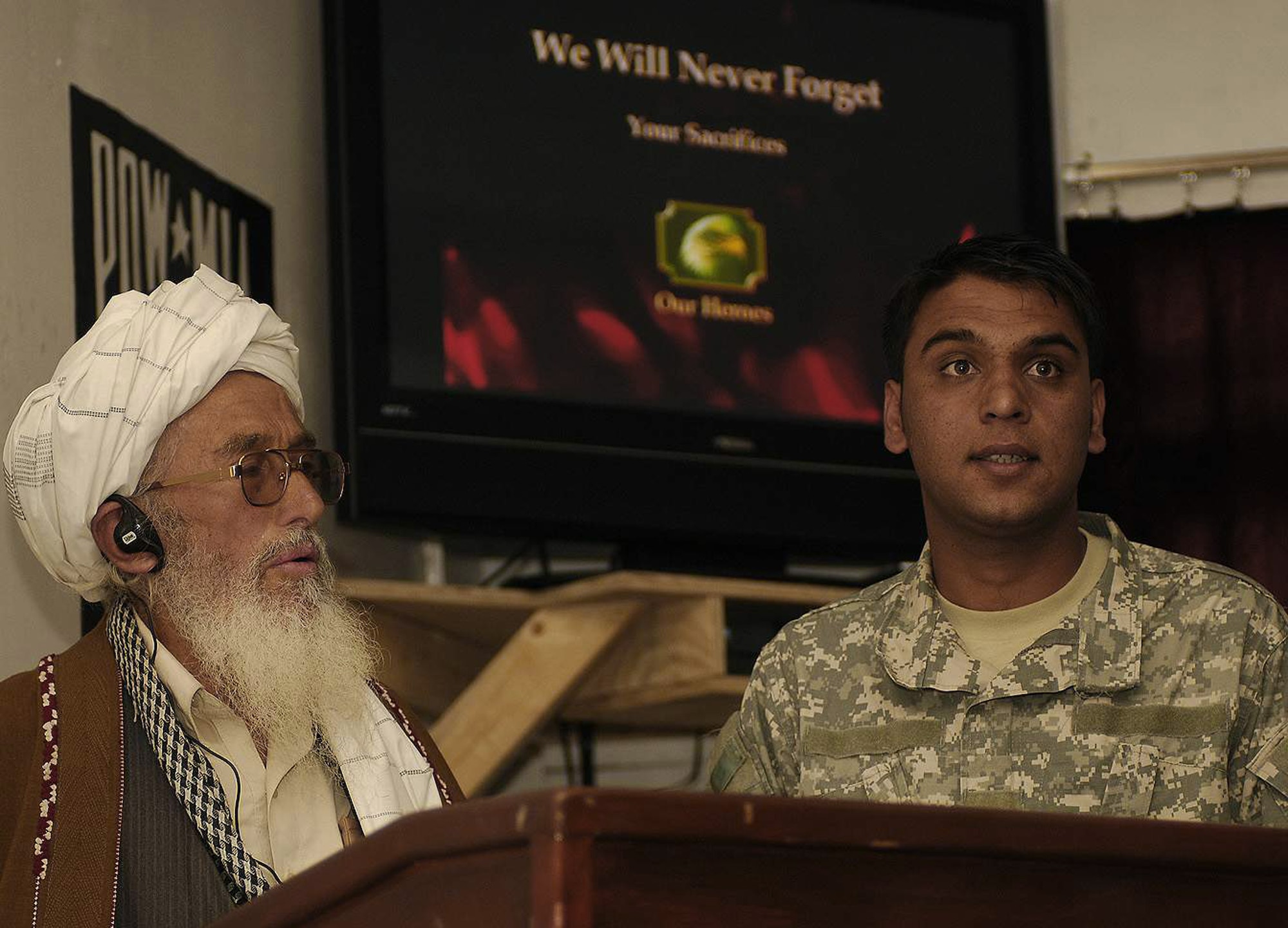 A Panjshir mullah, assisted by Qader, a Panjshir Provincial Reconstruction Team interpreter, offers a prayer and expresses his condolences for the loss of four members of the Panjshir Provincial Reconstruction Team during a May 31 memorial at Forward Operating Base Lion, Afghanistan. The mullah also shared his heartfelt appreciation for the sacrifices the team has made to improve the lives of Afghans living in Panjshir Province. (U.S. Air Force photo/Staff Sgt. Jason Lake) 
